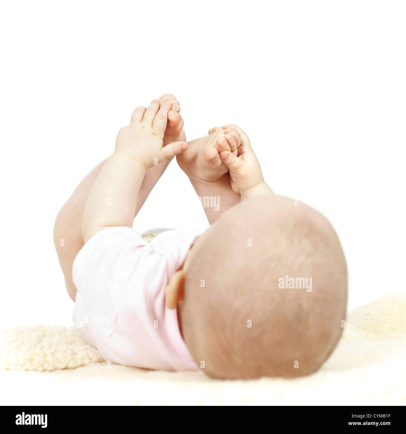 Young baby playing with her toes Stock Photo