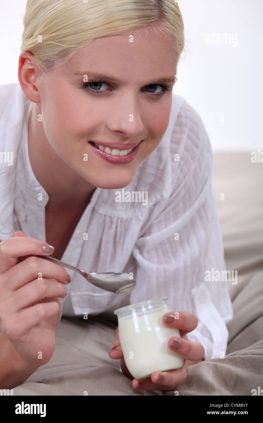 Woman eating yogurt in bed Stock Photo Alamy