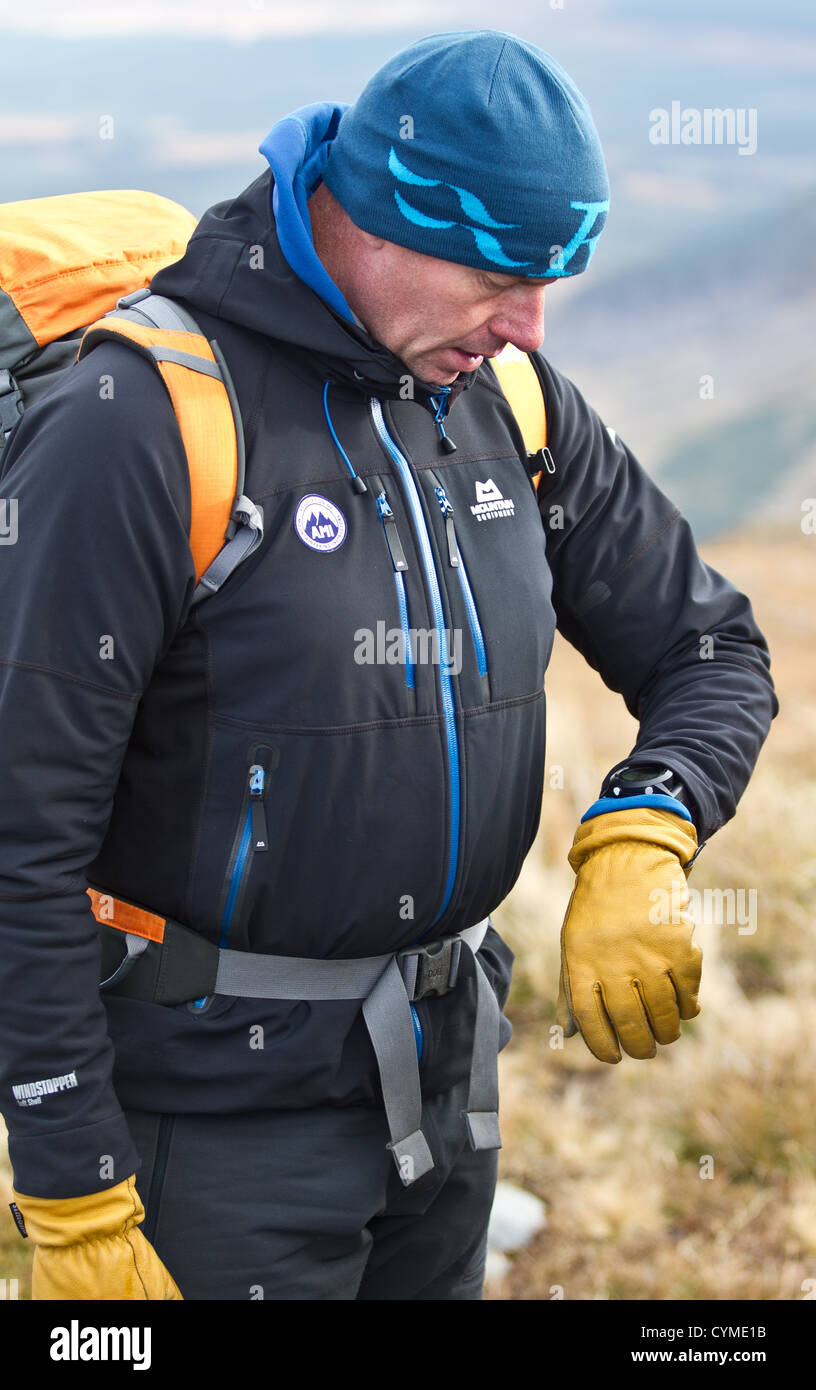 A man using a wrist watch GPS navigation system in the Scottish Mountains at Aonach Mor near Ben Nevis Stock Photo