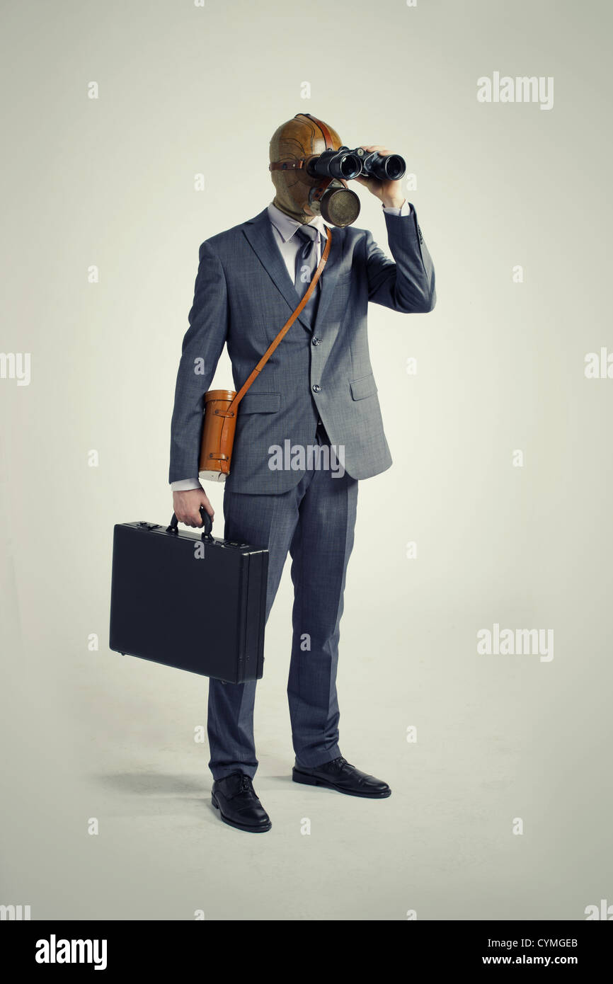 Businessman with gas mask  looking through binoculars Stock Photo