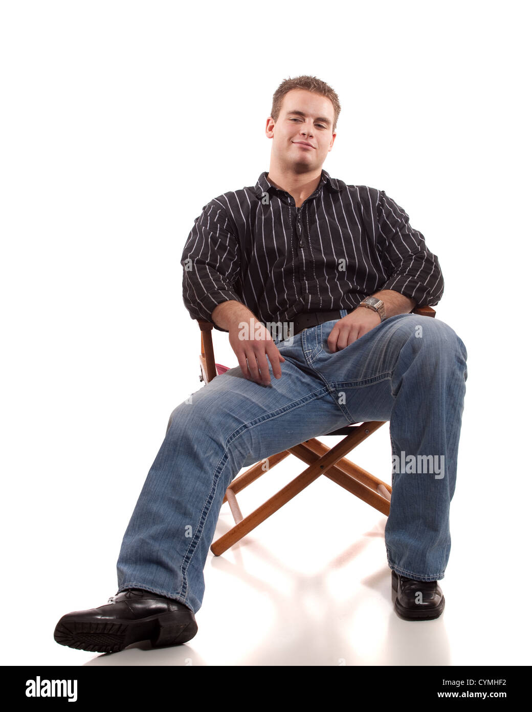 Casual young man seated in directors chair. Stock Photo