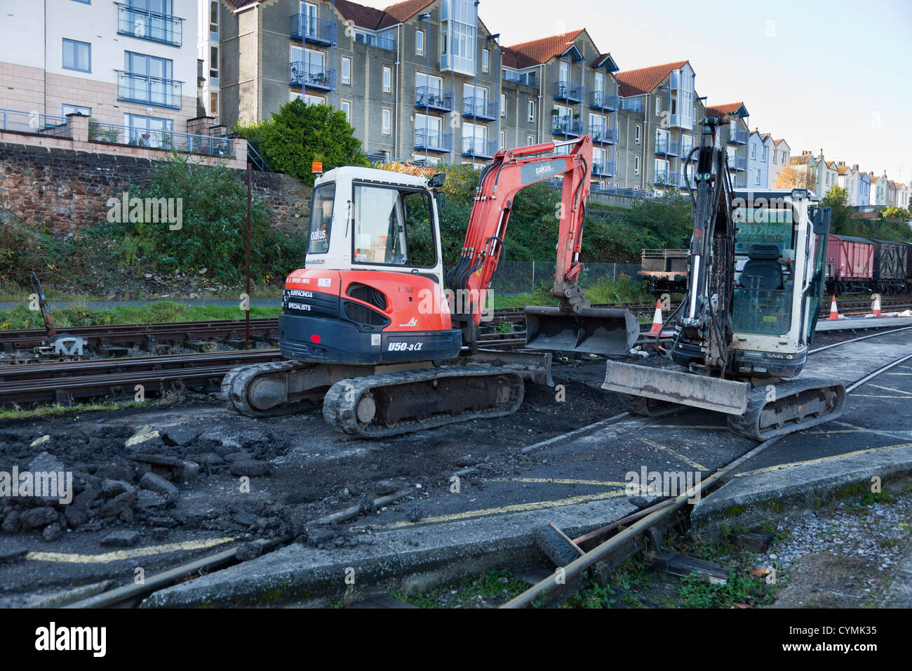 Two small tractor diggers parked up used in small scale track repairs in Bristol old city center docklands. Stock Photo