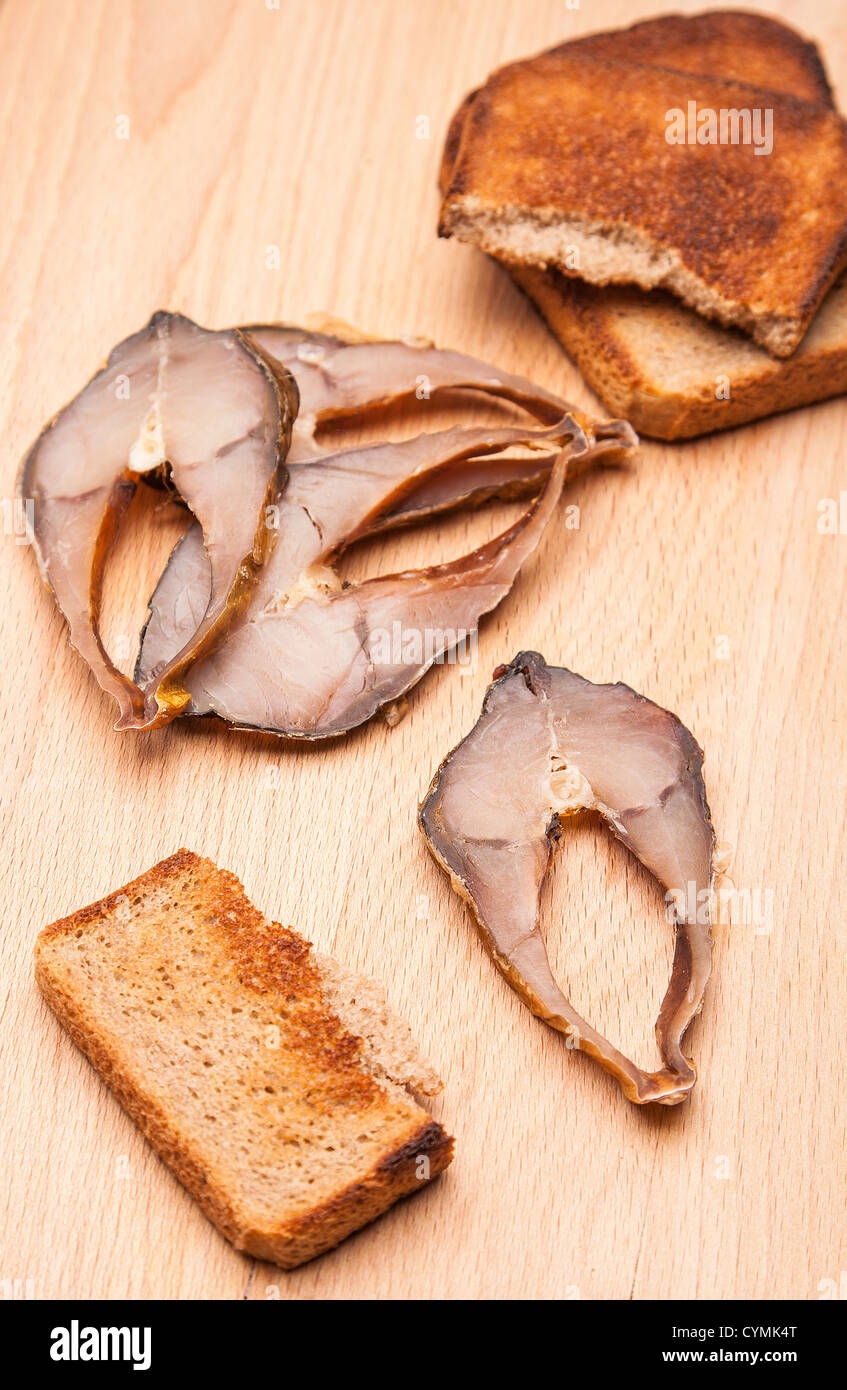 toast from bread with pieces smoked fish on wood Stock Photo