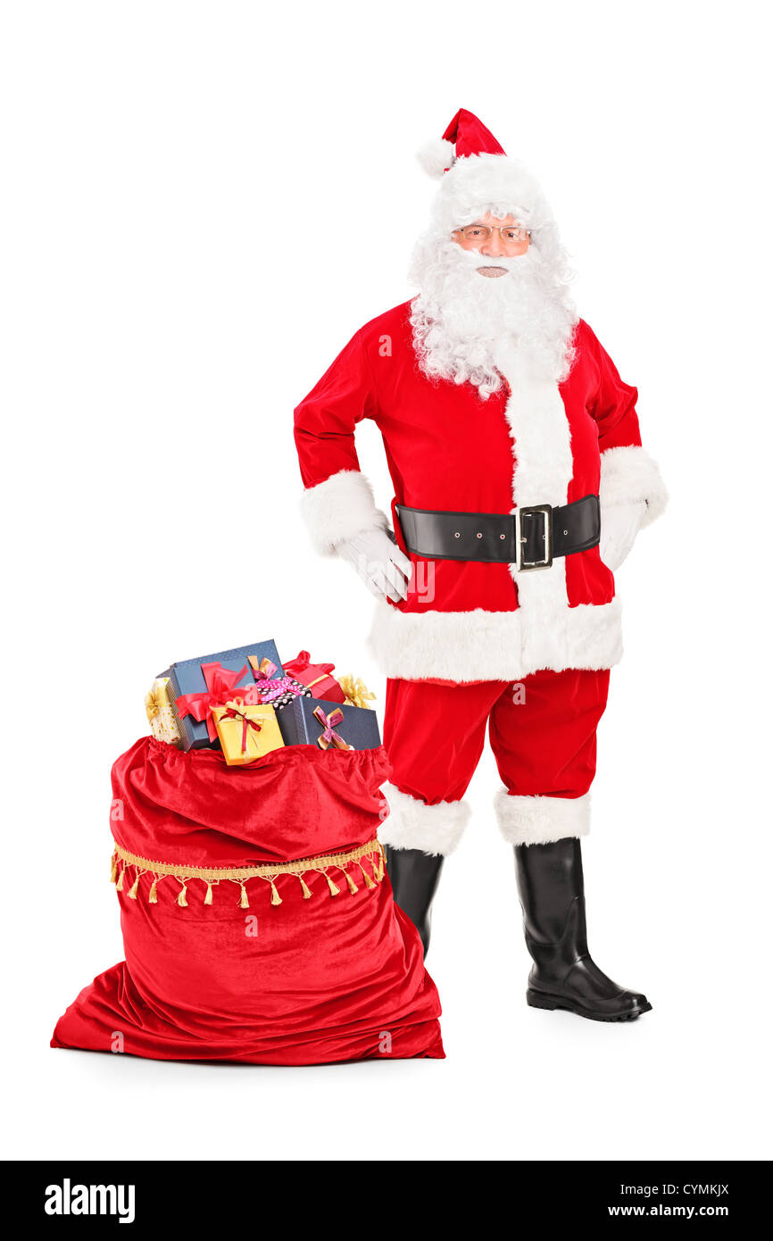 Full length portrait of a Santa Claus posing next to a bag full of ...