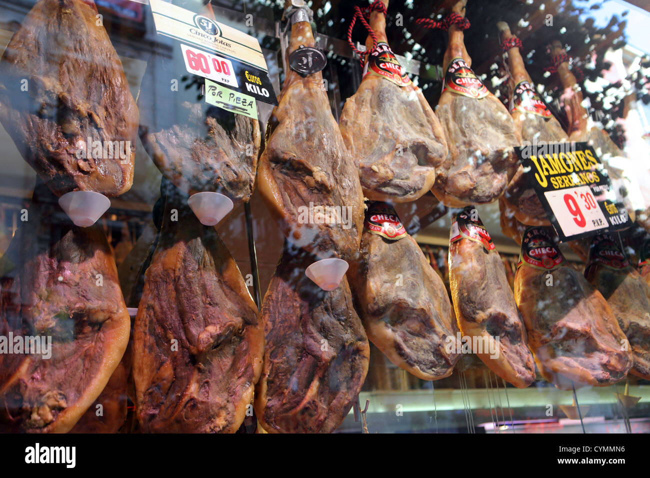 Serrano Ham Jamones cured preserved pork hanging up in bar grocery butcher shop Madrid Spain Stock Photo