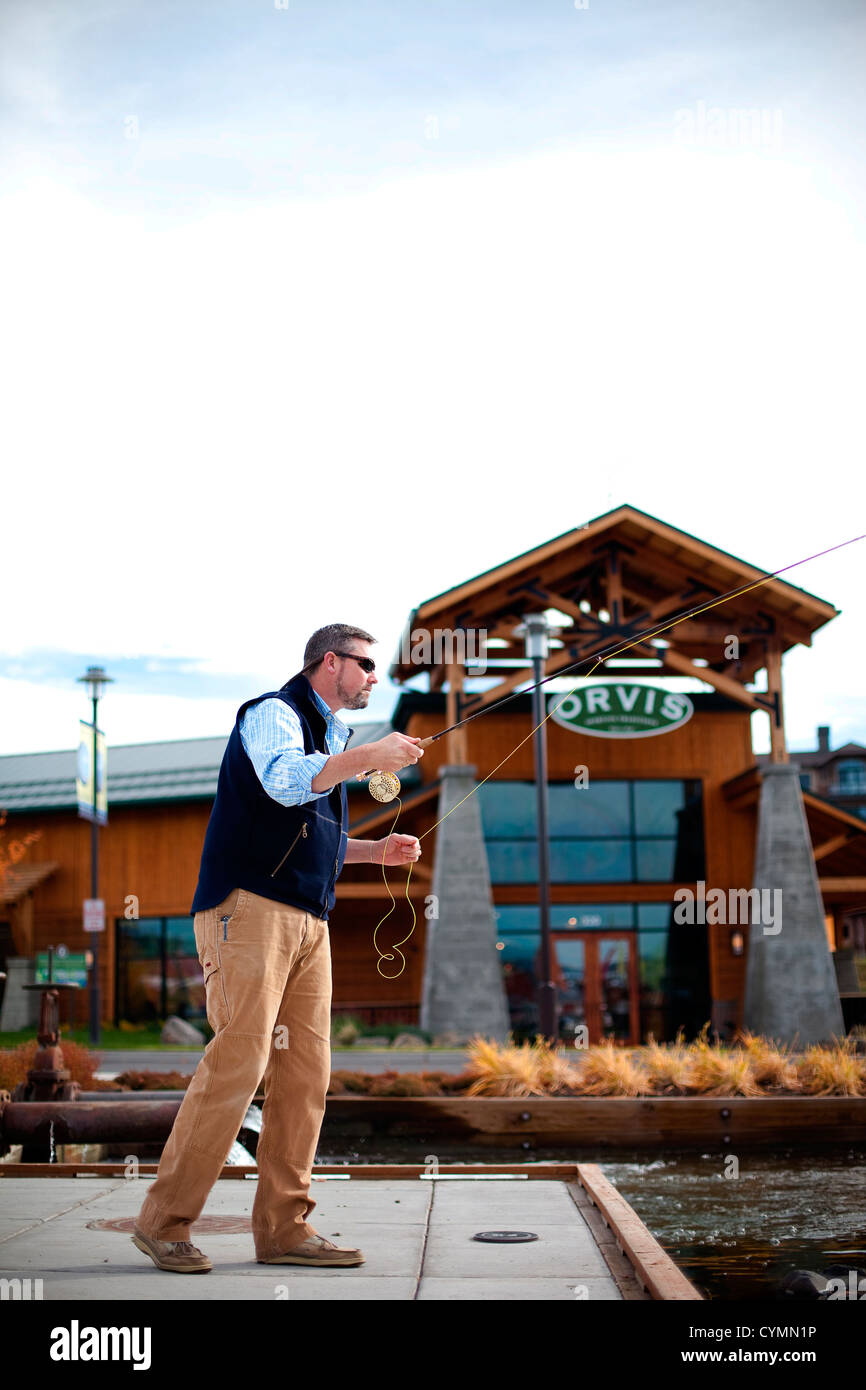 A man practices his fly fishing outside the Orvis store in Bend, Oregon. Stock Photo