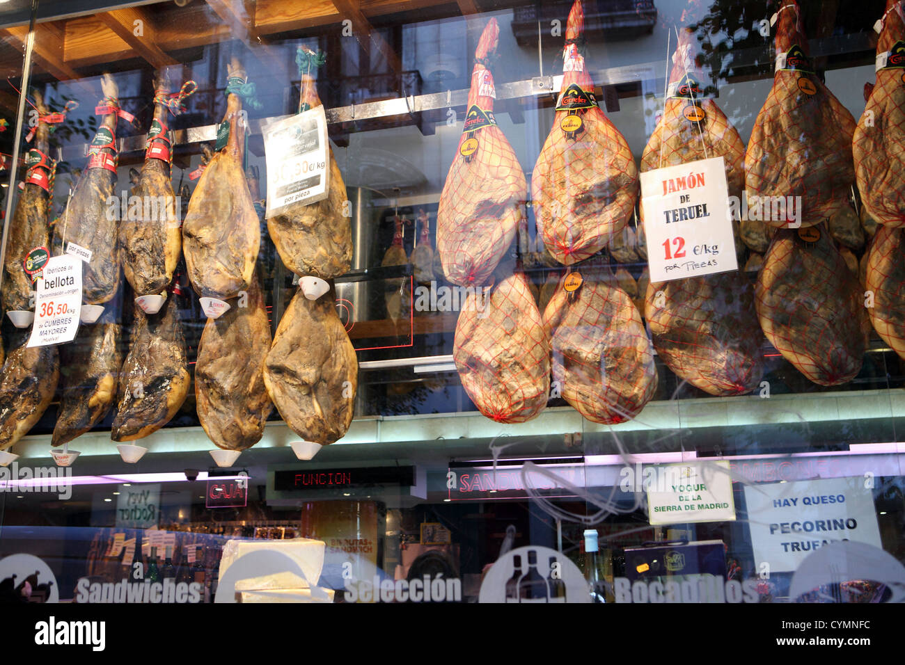 Serrano Ham Jamon cured preserved pork hanging up in bar grocery butcher shop Madrid Spain Stock Photo