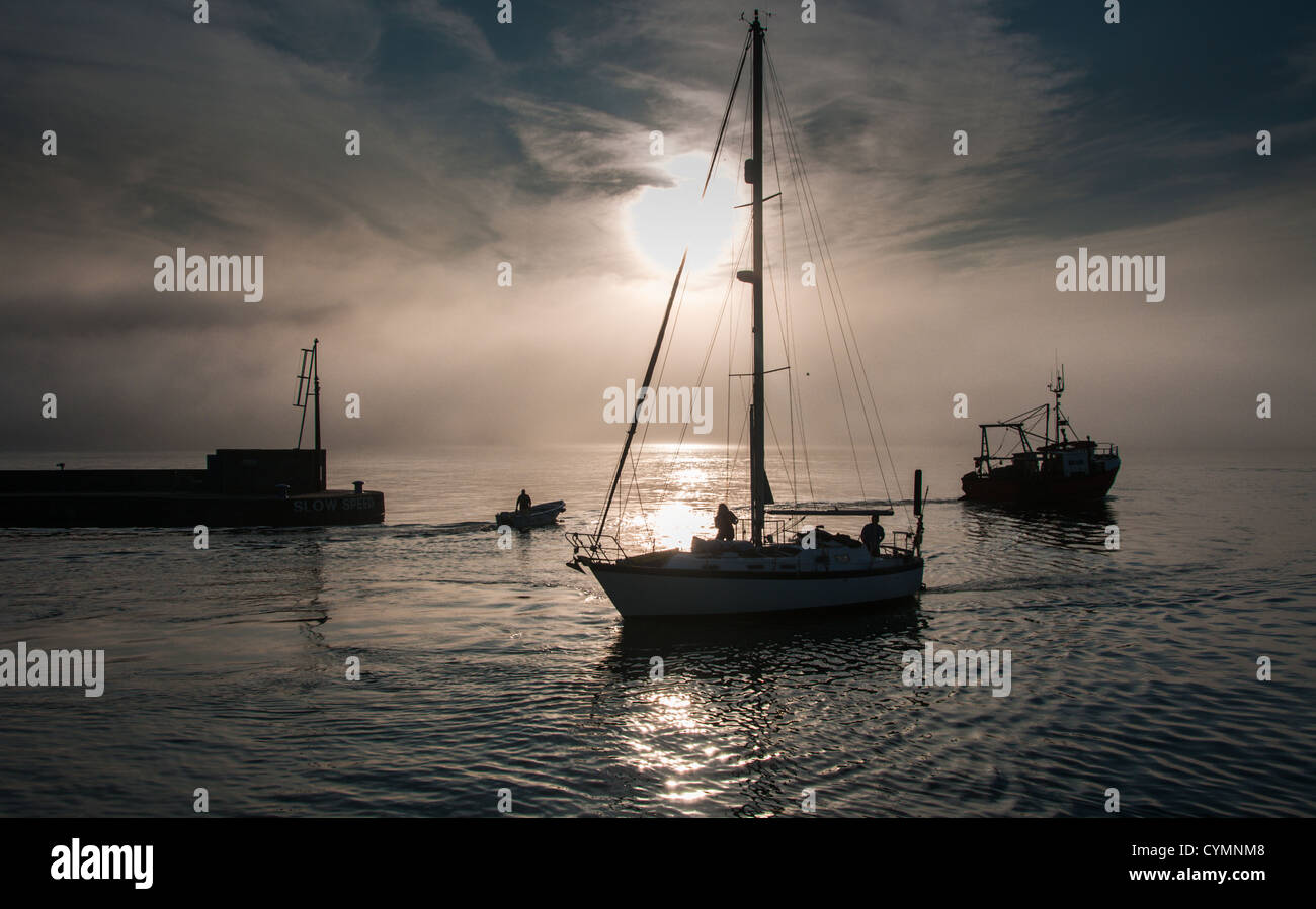 Padstow harbor entrance at sunrise with yacht and fishing boat Stock