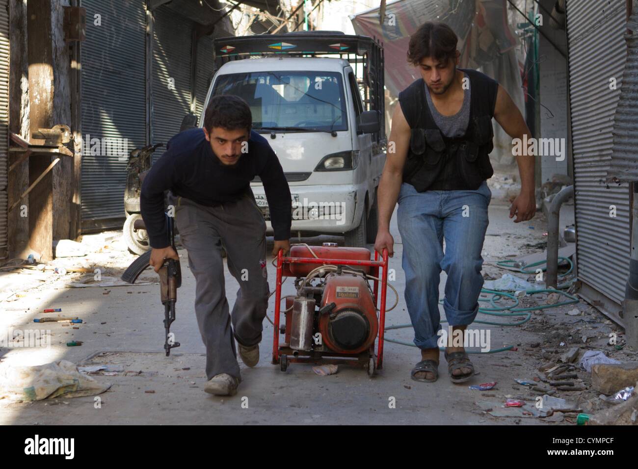November 5, 2012 - Aleppo, Syria:  Free Syrian Army Fighter carry a generator to a location where injured fighters area trapped in the Old City. They needed to cut through a concrete wall to avoid sniper fire which killed one in a rescuer attempt. Stock Photo