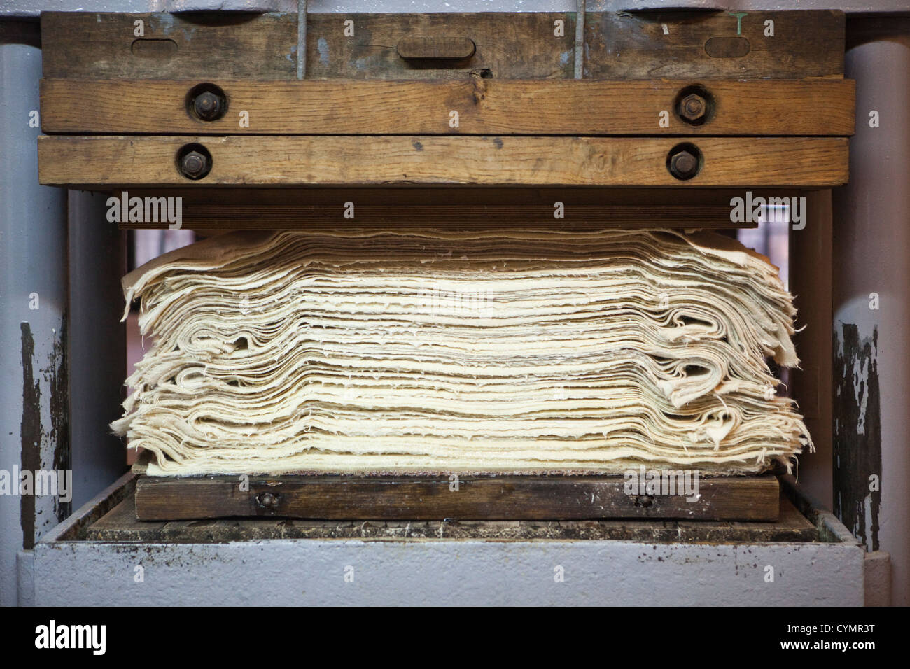 Freshly handmade paper is pressed to remove excess moisture at the historic Paper Mill in Duszniki-Zdroj, Poland. Stock Photo