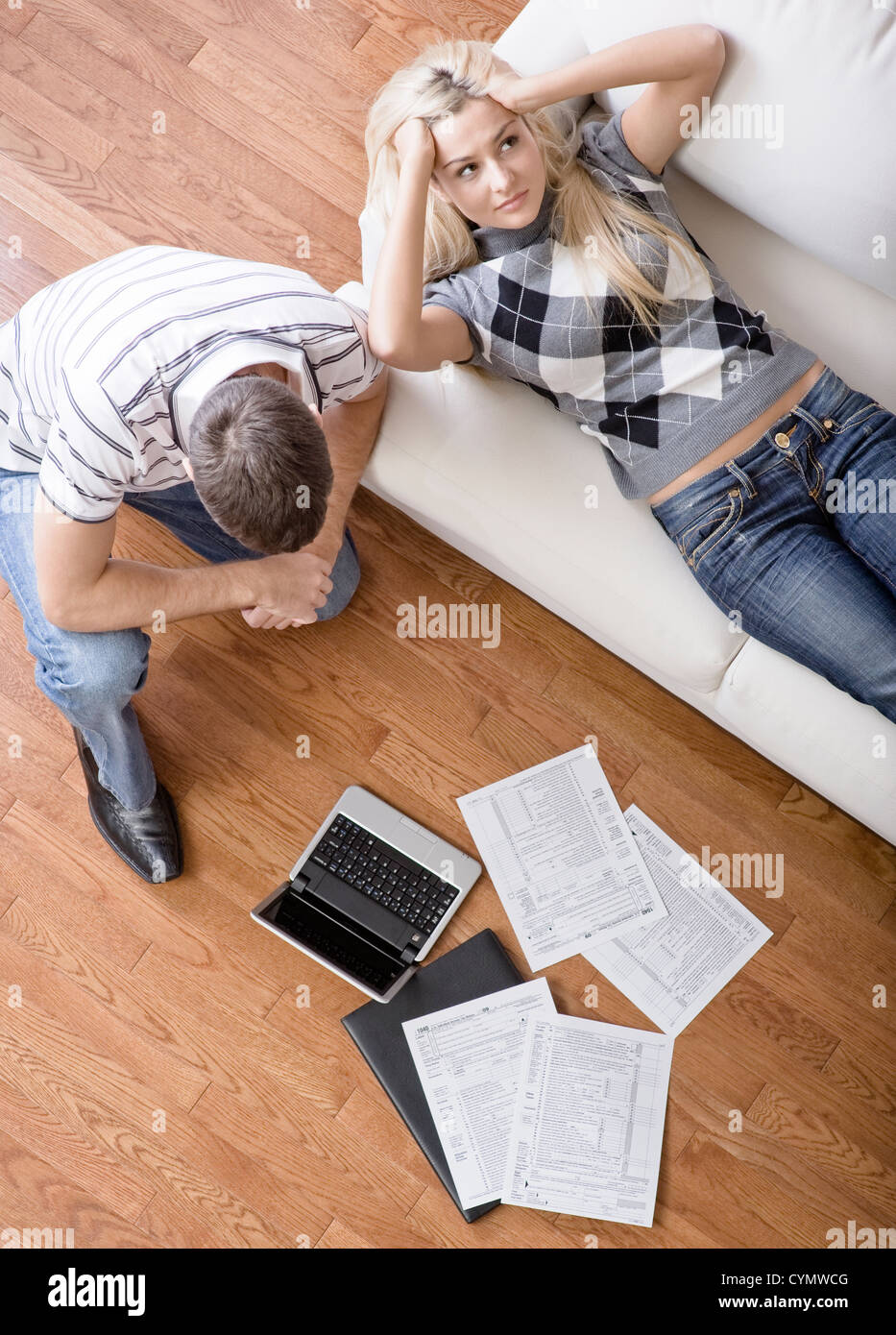 High angle view of a young couple frustrated while doing paperwork. Vertical shot. Stock Photo
