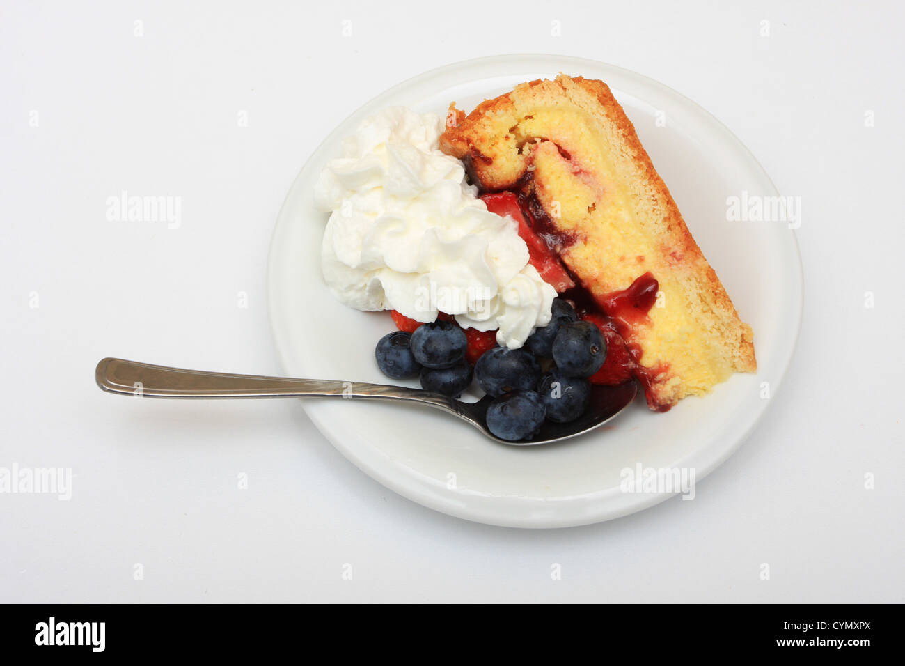 slice of strawberry cake with whipped cream and blueberries isolated on ...