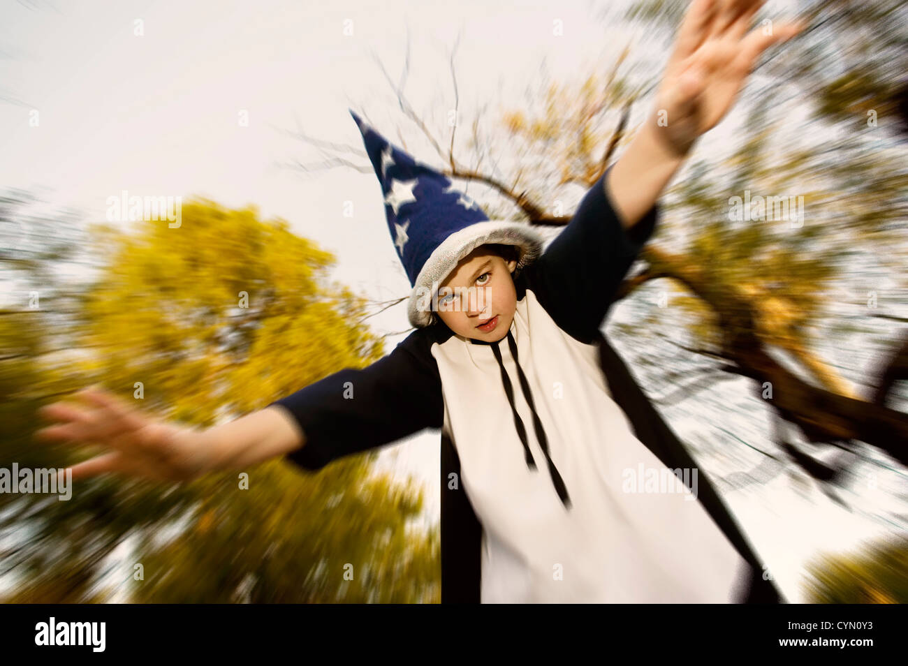 Young boy in a wizard costume with his arms outstretched Stock Photo