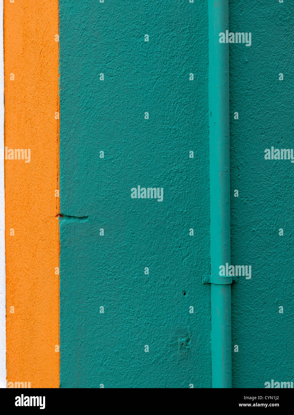A brightly-coloured wall painted in teal with an orange stripe in Burano, Venice Stock Photo