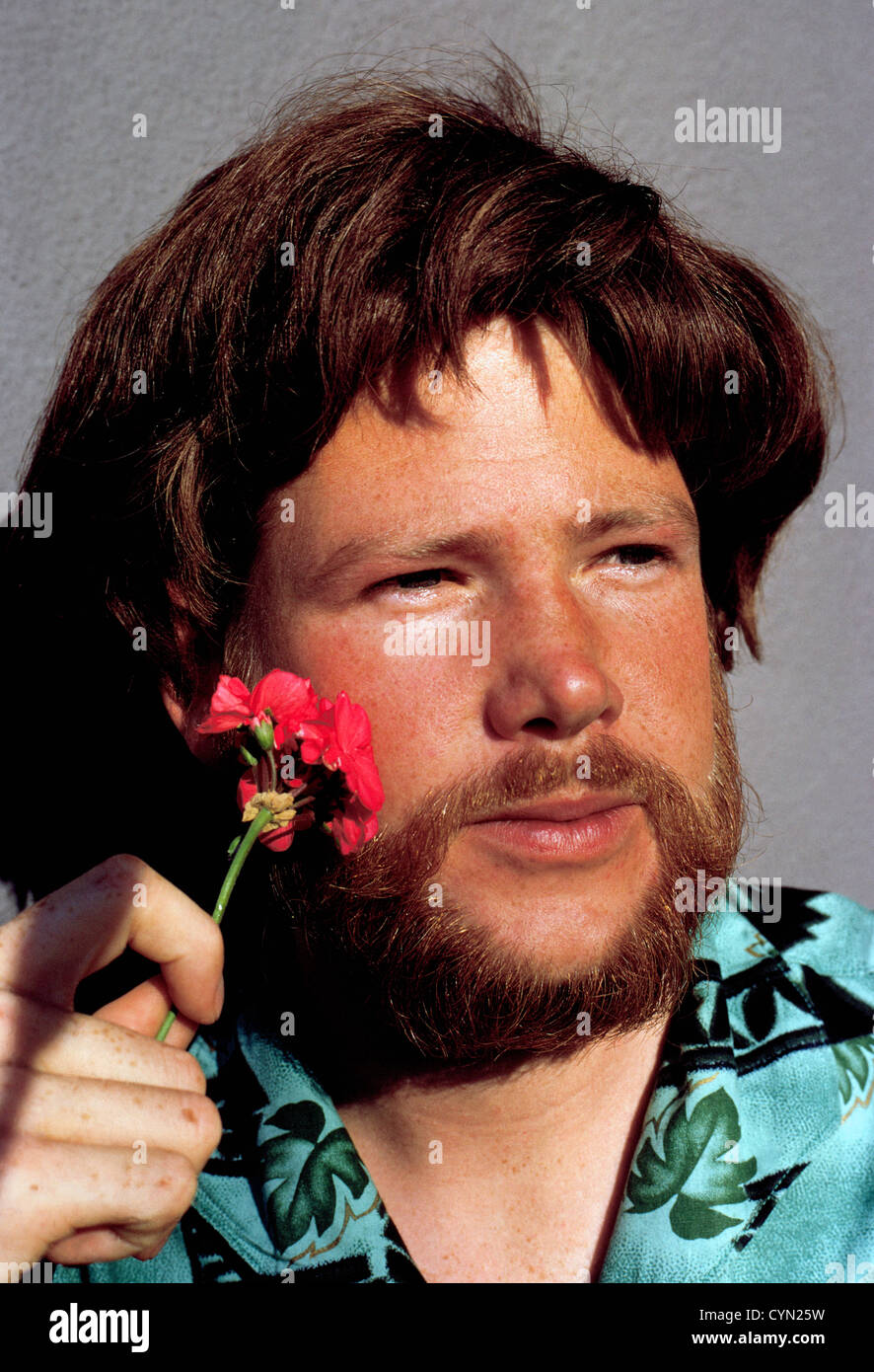 A young hippie man with long hair, beard, and flower was photographed in 1967 in San Francisco, California, USA. Stock Photo