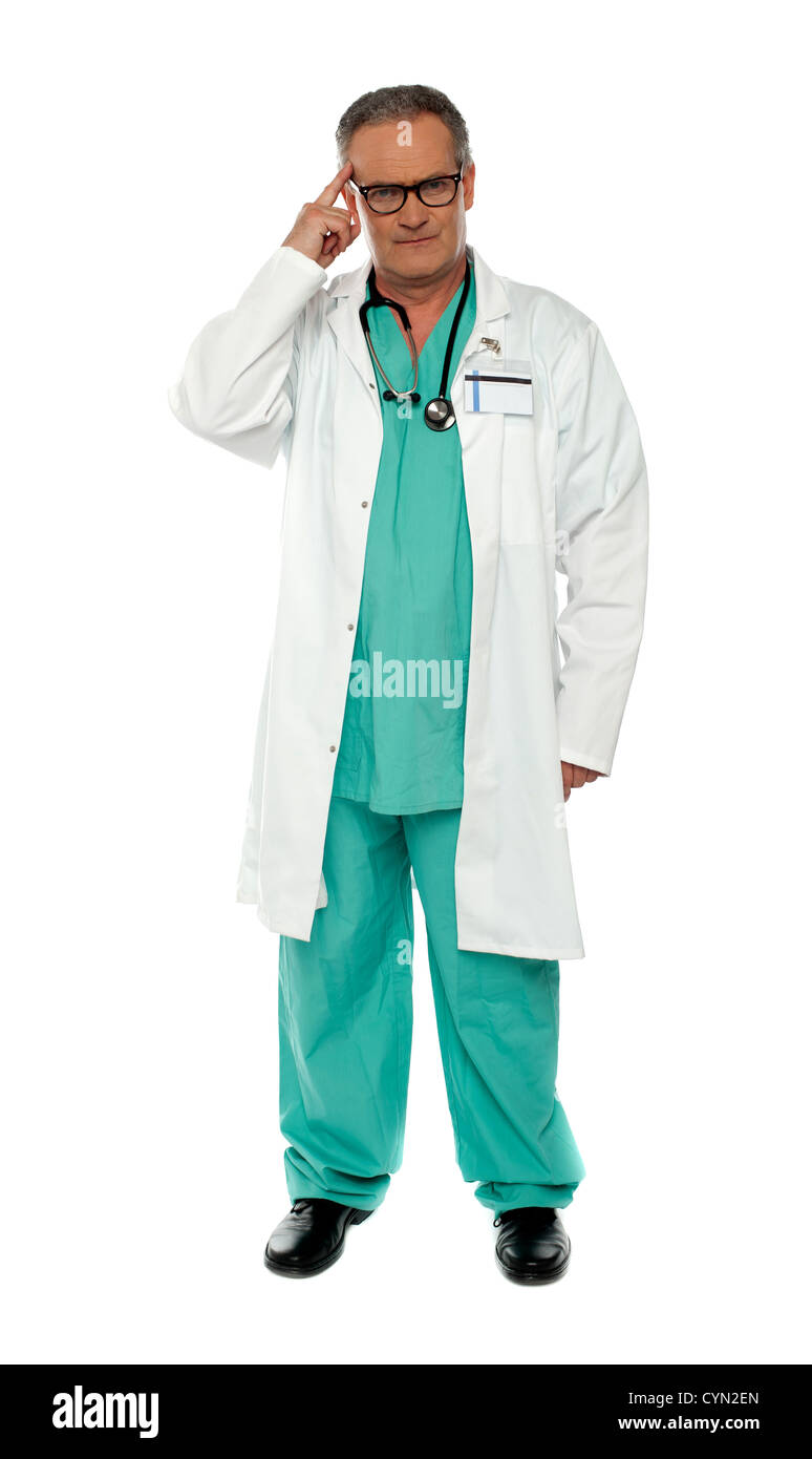 Portrait of thoughtful senior doctor posing with finger on his head ...