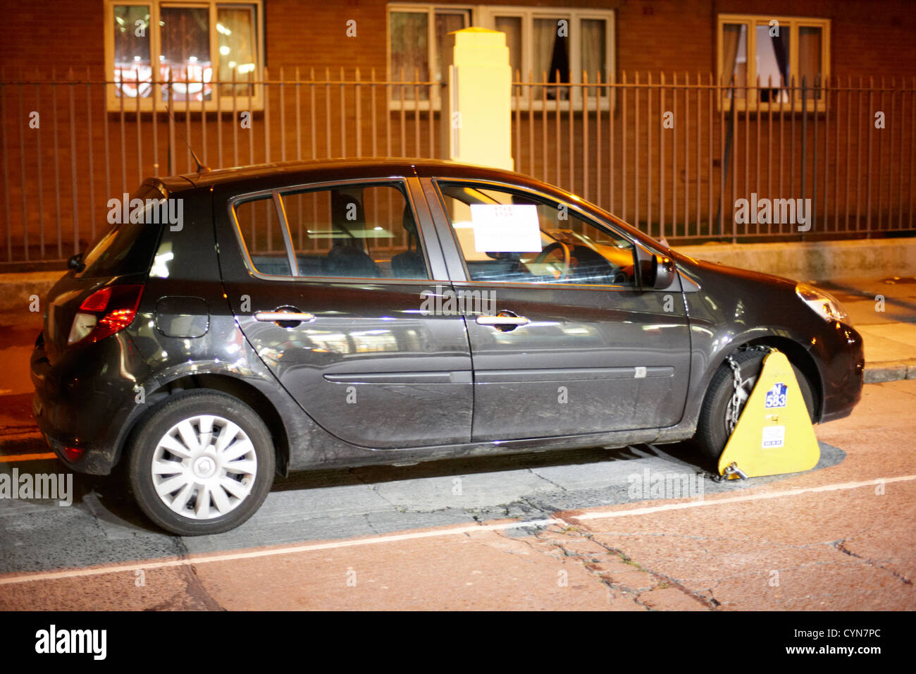 car clamped on a street at night in dublin republic of ireland Stock Photo