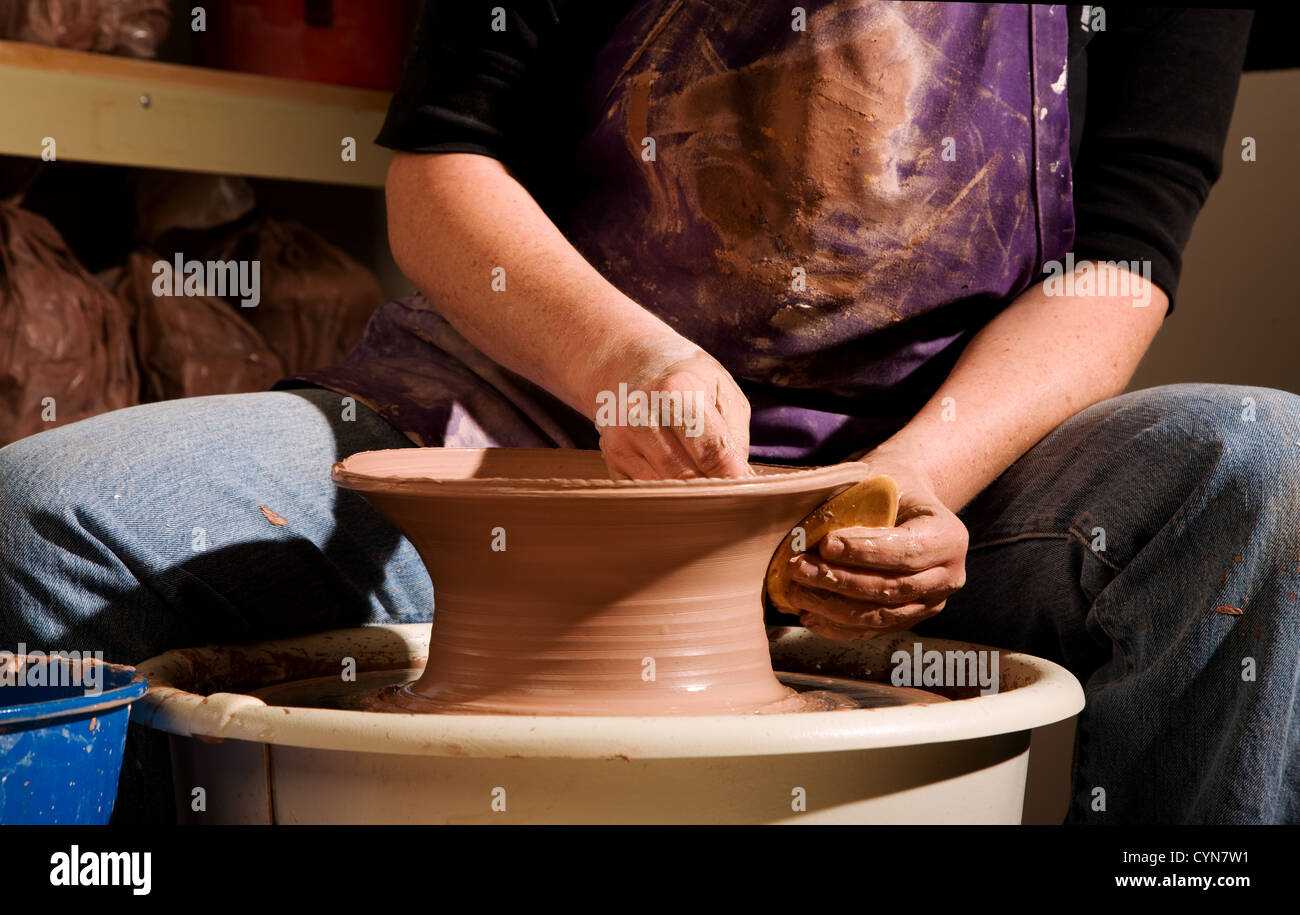 Potter shaping clay on a turning wheel Stock Photo - Alamy