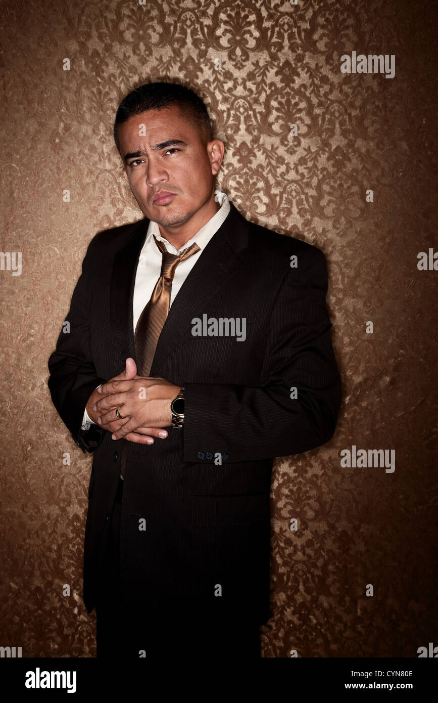 Handsome Hispanic Man in front of Gold Wallpaper background Stock Photo
