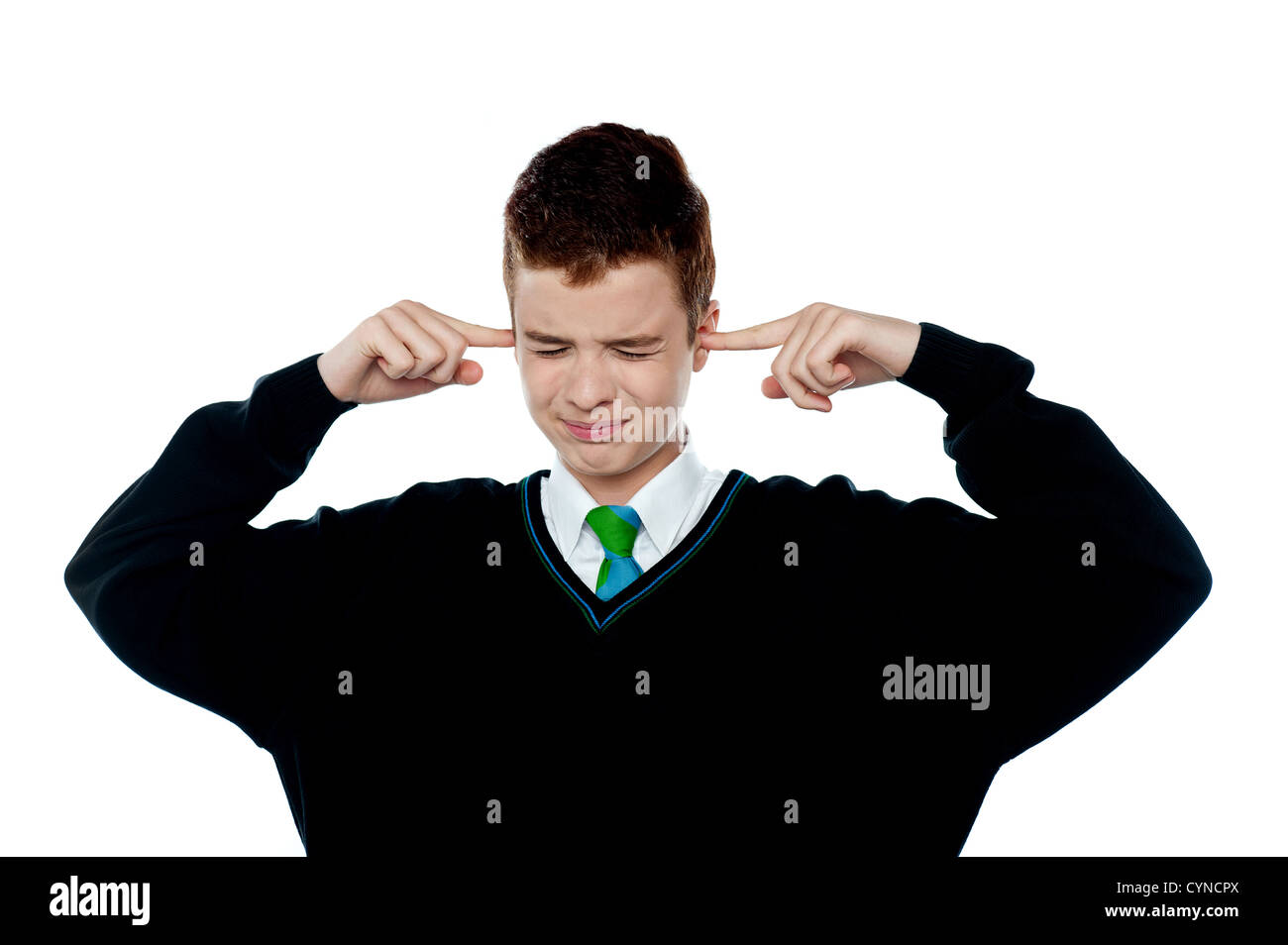 Loud noise becoming unbearable for kid. Boy with fingers on his ears Stock Photo