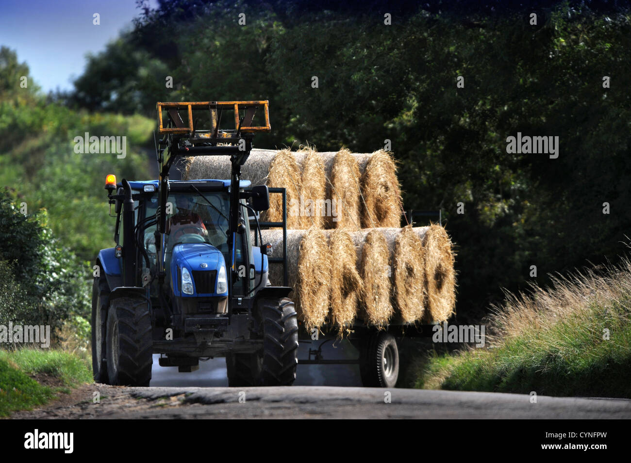 A tractor pulling a trailer of hay bales in Gloucestershire UK Stock Photo