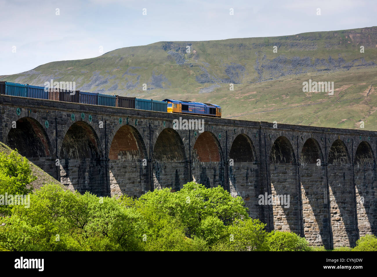 Class 66 deisel electric locomotive pulling a freight train over Ribblehead viaduct, North Yorkshire Stock Photo