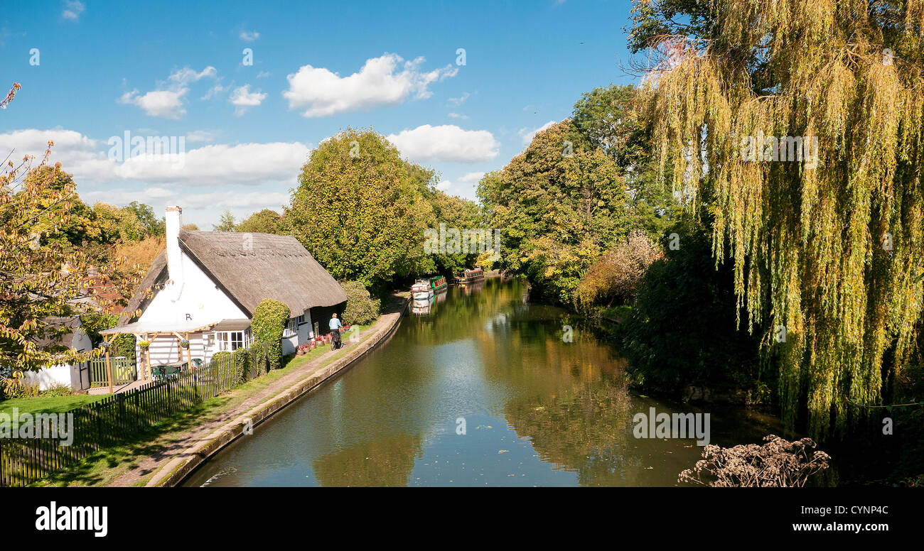 A thatched cottage and narrow boats on the Grand Union Canal, Marsworth, Buckinghamshire, UK Stock Photo
