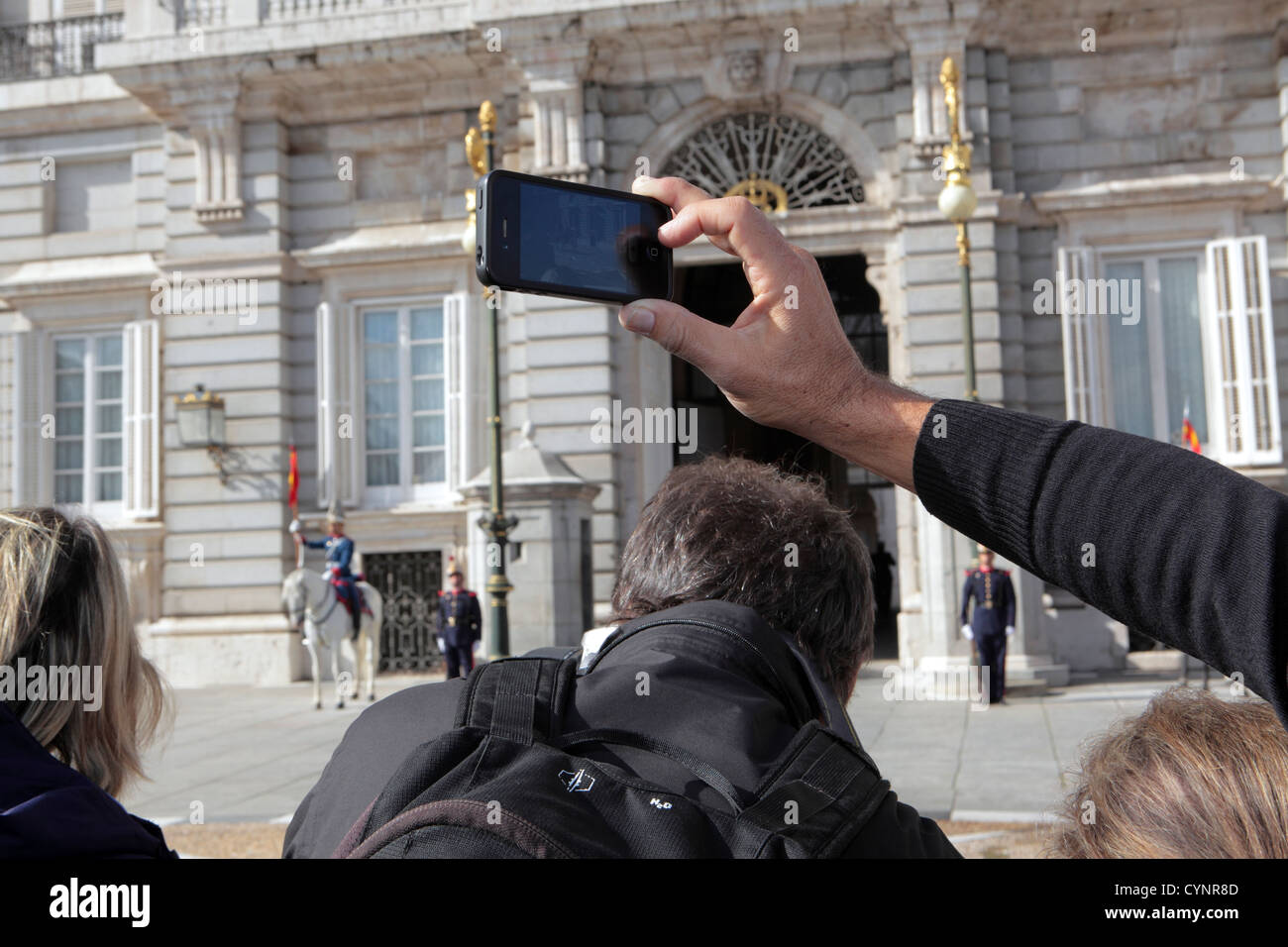 Tourist taking photographs with smart iPhone at Real Royal Palace, Madrid, Spain Stock Photo
