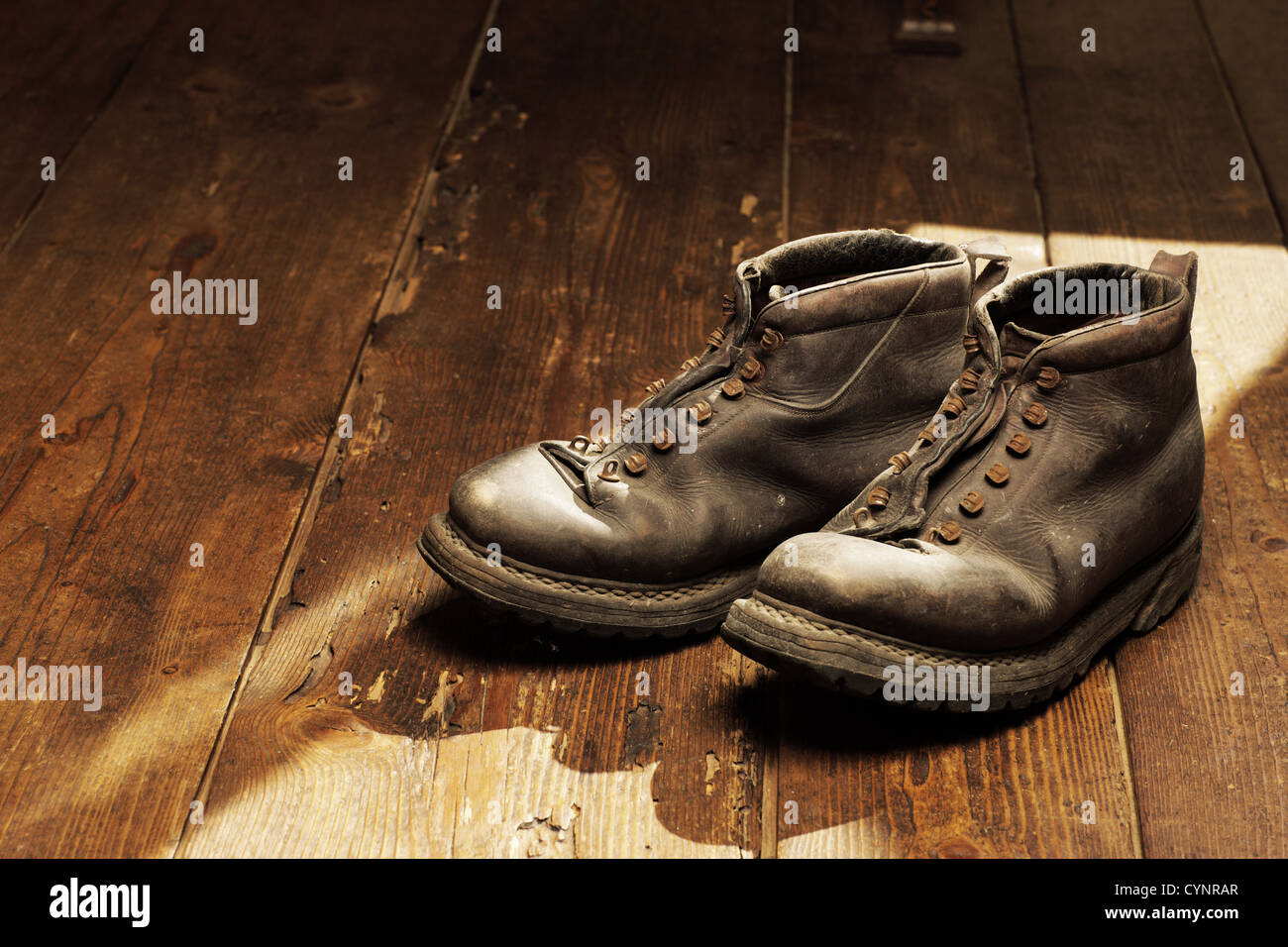 Old boots on the wooden floor, copy space Stock Photo