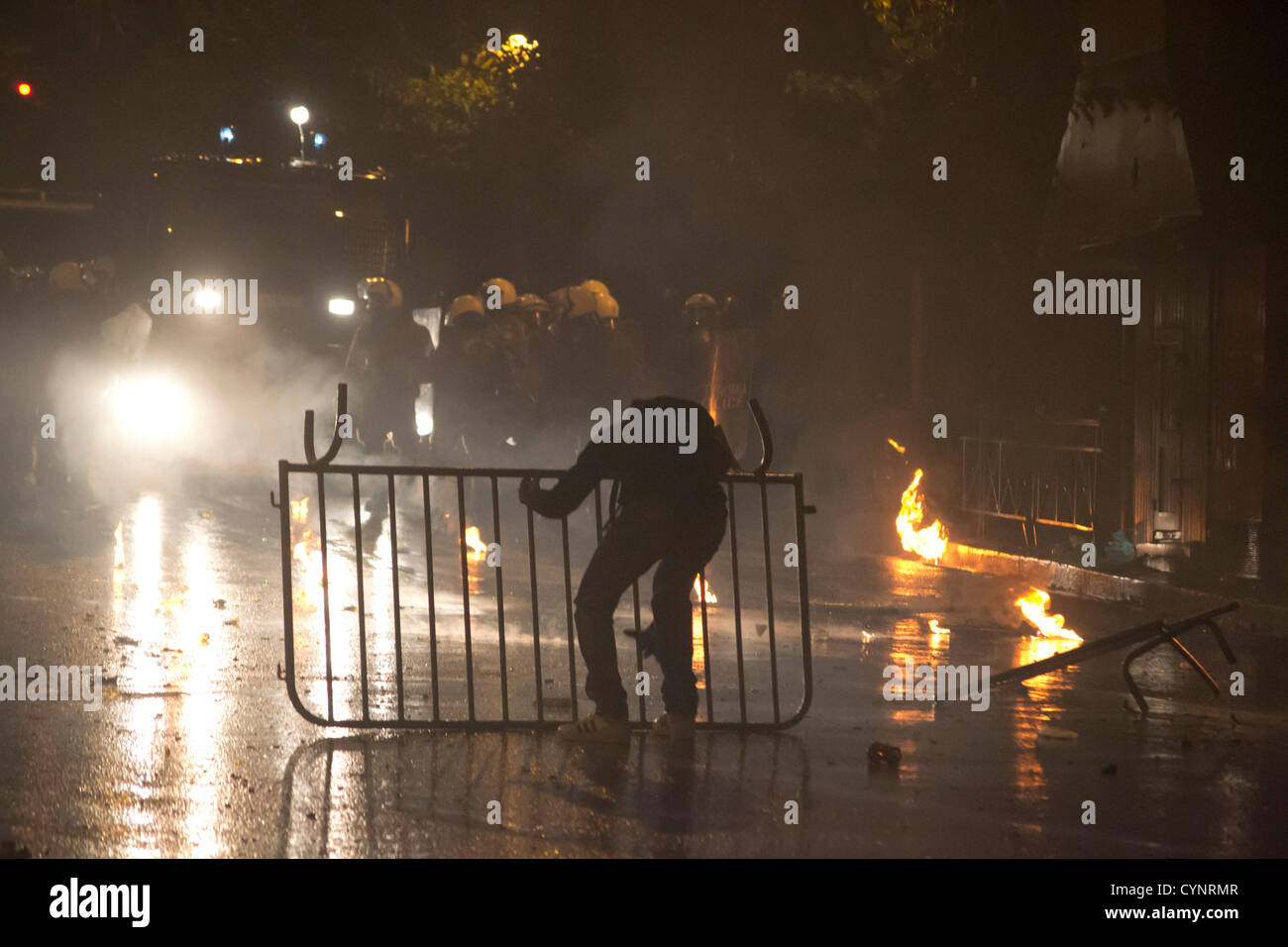 Protester confronts riot police outside the Greek Parliament. Stock Photo