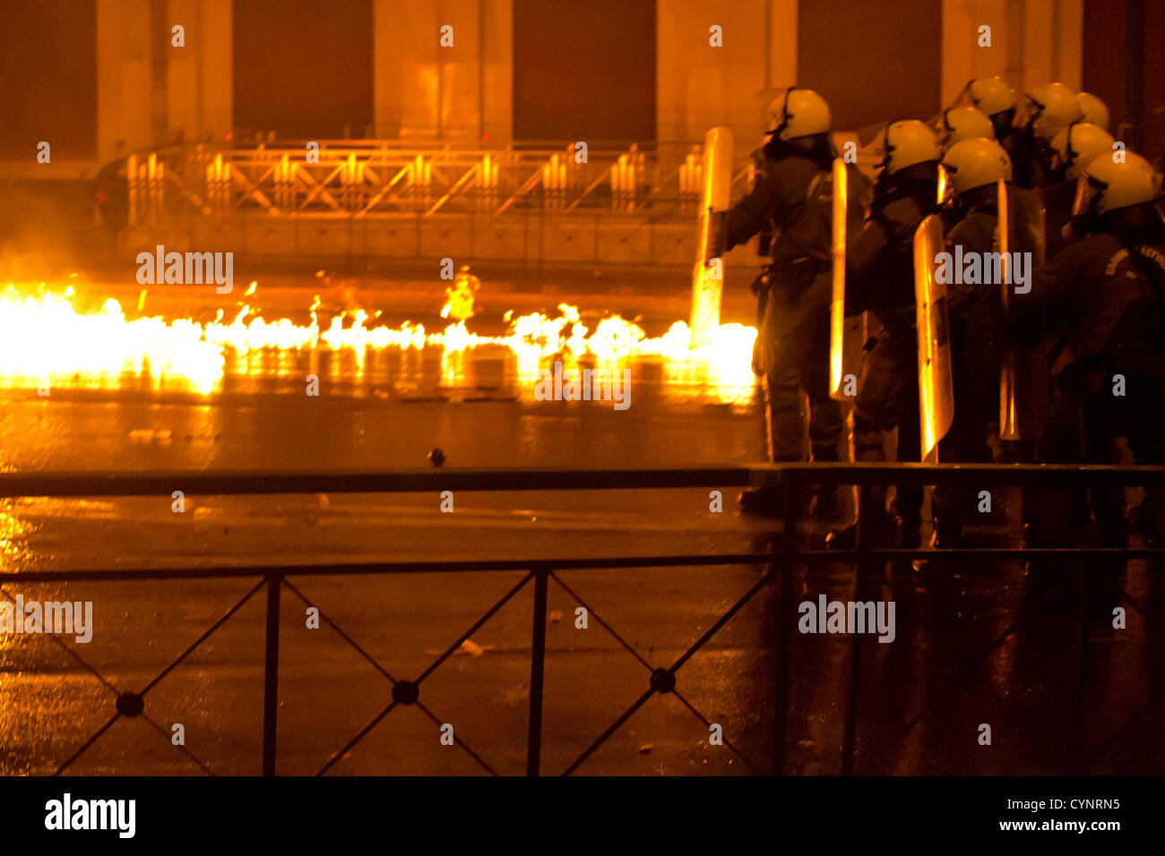 Flames surround riot policemen outside the Greek Parliament. Stock Photo