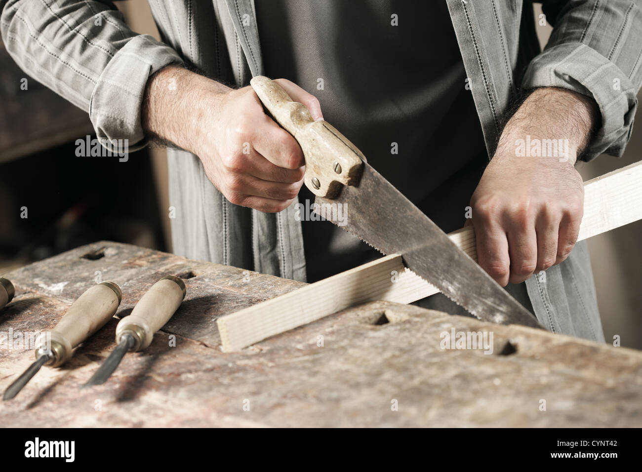 Carpenter saws plank by handsaw Stock Photo