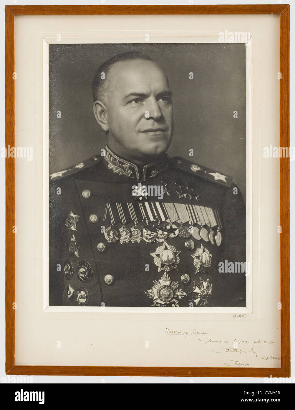 Marshal Georgy Konstantinovich Zhukov (1896 - 1974) - a photo with dedication to General Koenig, Portrait picture in marshal's uniform with numerous medals. The mount with a Cyrillic dedication handwritten in dark ink 'To the French General Koenig, respectfully Marshal Zhukov, City of Berlin 11/09/45'. On the lower right the photographer's signature 'G. Veil'. Framed and under glass, dimensions 55 x 42 cm. Marshal Zhukov was head of the general staff and Soviet secretary of defence. He became known for successfully defending Moscow and emerging victorious in th, Stock Photo