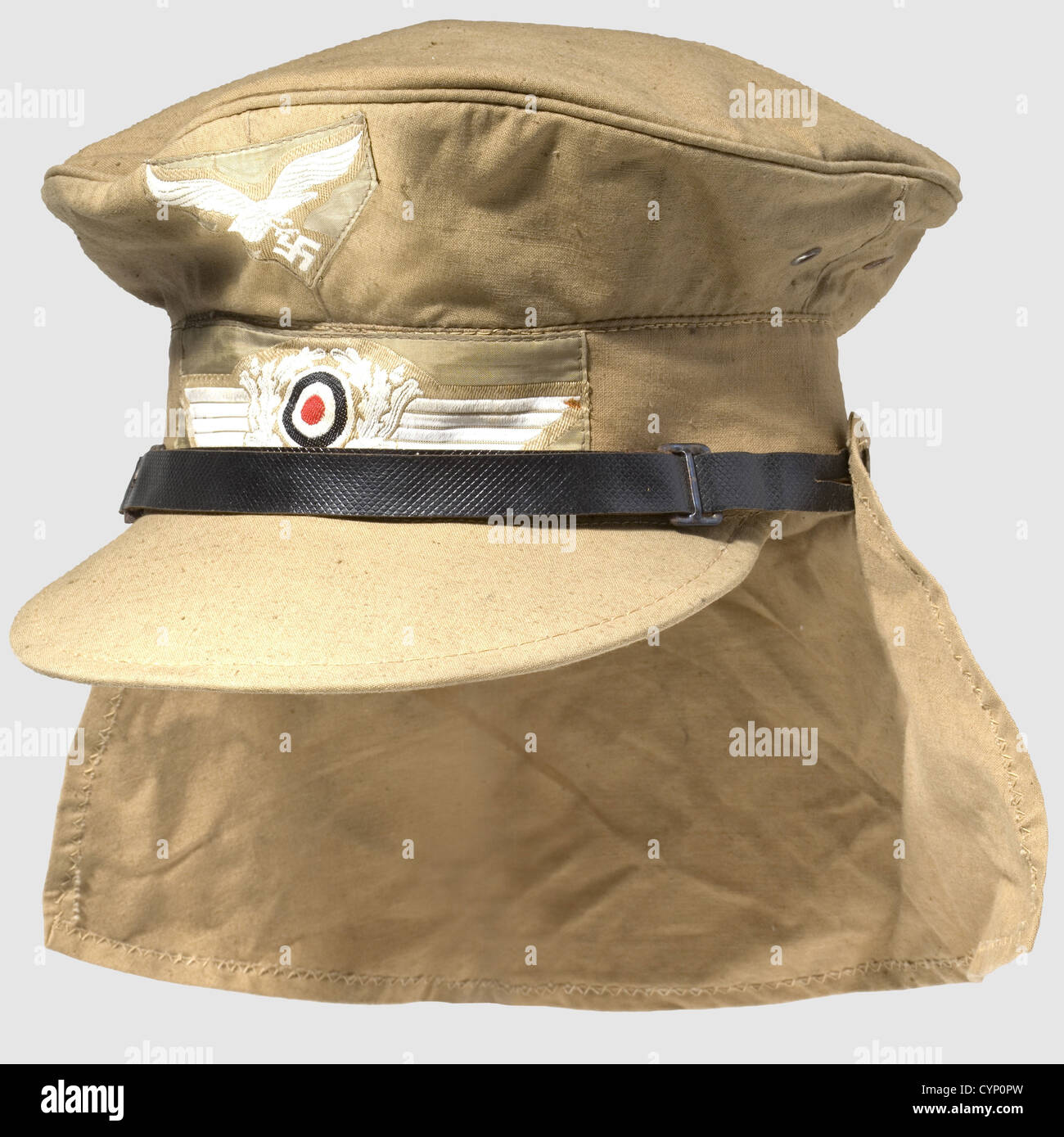 A visor cap for the tropical uniform,the so-called 'Hermann Maier Mütze'. Soft issue of sand-coloured cotton,iron ventilation eyelets and woven insignia on a sand-coloured background,tooled waffle-patterned black chin strap(damaged),button-up neck shield of the same material. Red cover liner with 1943 RB number stamping,sweat band of cap material. Size 57,never worn,slightly crumpled,historic,historical,1930s,20th century,Air Force,branch of service,branches of service,armed service,armed services,military,militaria,air forces,object,objec,Additional-Rights-Clearences-Not Available Stock Photo