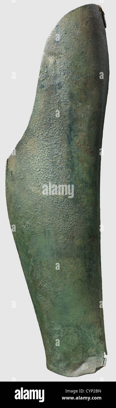 A Greek bronze greave,6th century B.C.Massive right greave,shaped with little anatomical details.Without any lining or lacing holes,but with a single hole in the upper knee area which suggests that it was probably fastened to a tropaion in a sanctuary.Losses and cracks to the lower edge.Length 46.5 cm.Metal tag with inventory number of the former collection Marzoli,today museum Brescia.Green patina,partially with soil encrustation.Axel Guttmann Collection(AG 622/R 152).Perfectly preserved metal.Beautiful high archaic greave,historic,historical,,Additional-Rights-Clearences-Not Available Stock Photo