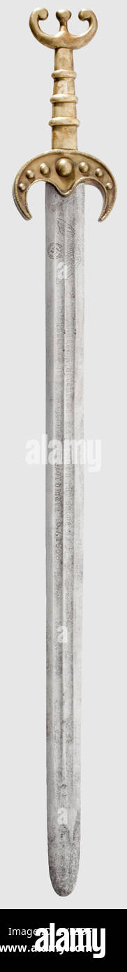 A presentation sword 1938,Reproduction of a Germanic sword,either side of the blade with double fullers and the etched dedication 'Our esteemed comrade for his services to the Nordmark 15.7.38'(transl.),next to the SS eagle,one side bearing the motto 'Meine Ehre heißt Treue'(Loyalty is my honour)with SS runes.Brass hilt made of several parts,with antenna pommel.Cleaned traces of surface rust.Length 95 cm.A present to a high-ranking SS officer of the 'Forschungsgemeinschaft Deutsches Ahnenerbe e.V.' Gift swords fashioned after ancient or early mediev,Additional-Rights-Clearences-Not Available Stock Photo