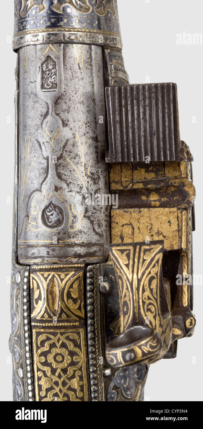 A fine Caucasian silver-mounted miquelet-lock pistol,mid-19th century.The round Damascus barrel with smooth bore in 14.5 calibre.Cut barrel rib,the breech with leaf decoration.Two stamped marks above the chamber,remains of gold inlay.The miquelet-lock encrusted in gold-inlaid foliage ornaments.The bottom side inscribed with maker's and owner's names.The stock entirely covered with sheet silver with fine niello decoration and partial gilding.The iron grip strap and trigger guard bear elaborate ornamentation in gold inlay,with a repeated signature on t,Additional-Rights-Clearences-Not Available Stock Photo