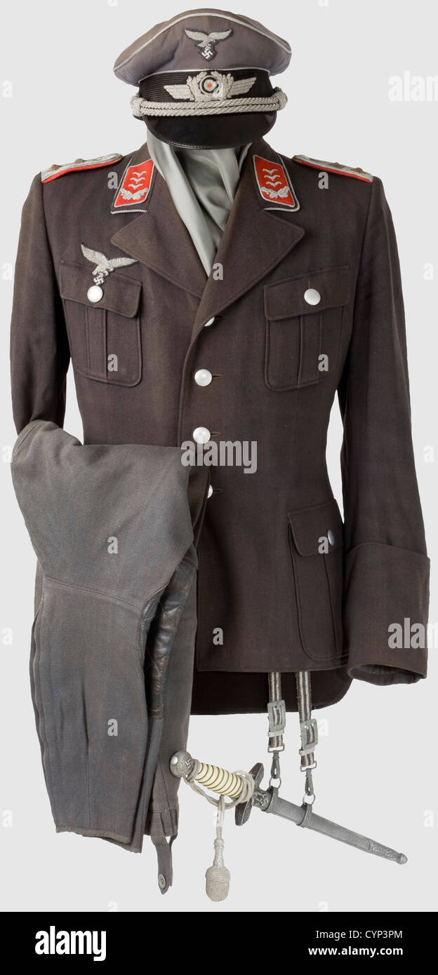 A walking-out uniform for a Hauptmann,of Flak Artillery.Visor cap of blue gabardine with black mohair band,silver piping and silver-embroidered insignia,silver cord.Bluish silk liner with gold stamped label 'Litto-Mütze Wien Sonderklasse'.Sweatband in poor condition,equipment stamped.Coat of Luftwaffe blue gabardine with silver buttons,silver-embroidered eagle and collar patches,sewn-on shoulder boards and collar cord.Silk liner in poor condition,moth damage.Breeches of blue gabardine with leather trim.Officer's dagger with white grip,hanger worn,Additional-Rights-Clearences-Not Available Stock Photo