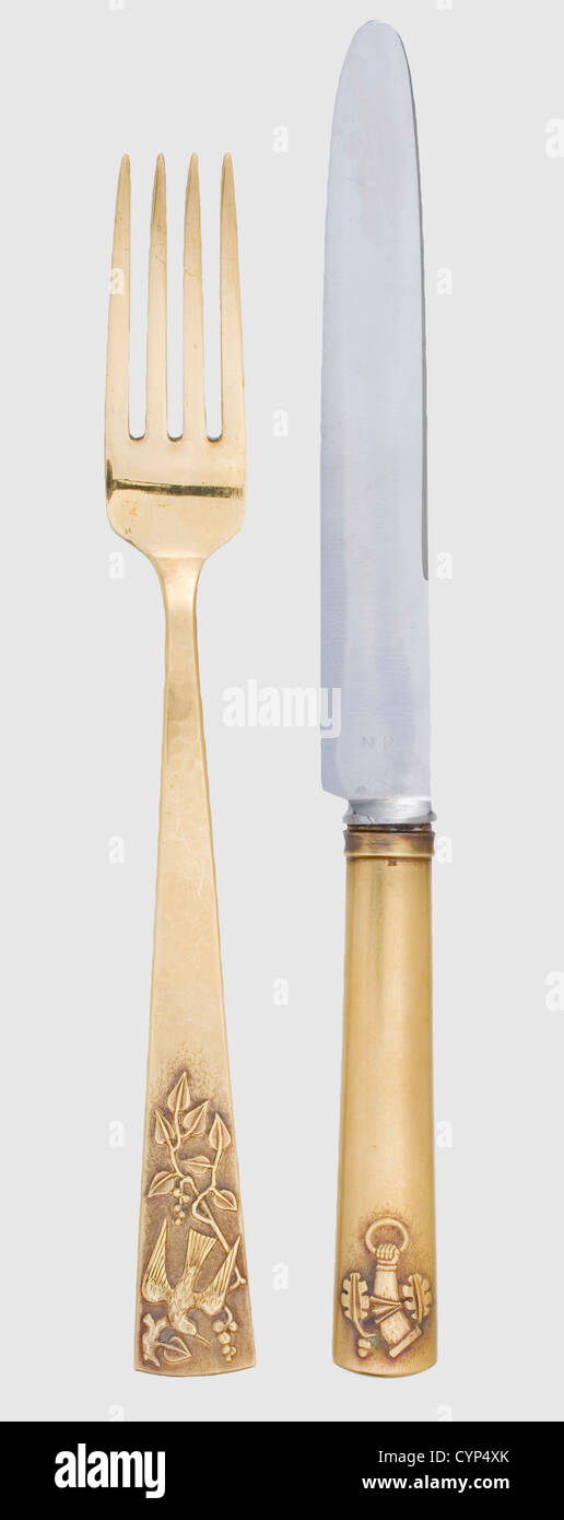 Hermann Göring and Emmy Sonnemann - a vermeil knife and fork,from the alliance silverware designed by Professor Zeitner for their wedding in 1935. Silver,gilt,the blade made of steel,hallmarked 'NR',on the handle the coat of arms of the Göring respectively Sonnemann family in relief as well as a hallmark '925',length 24.4 cm. The fork with hammered handle and floral decorations as well as a bird in relief,master's mark 'Z' of Professor Zeitner and hallmark '925',length 21.7 cm,weight 85 g. Extremely rare silverware. Cf. Hermann Historica,45th auction,,Additional-Rights-Clearences-Not Available Stock Photo