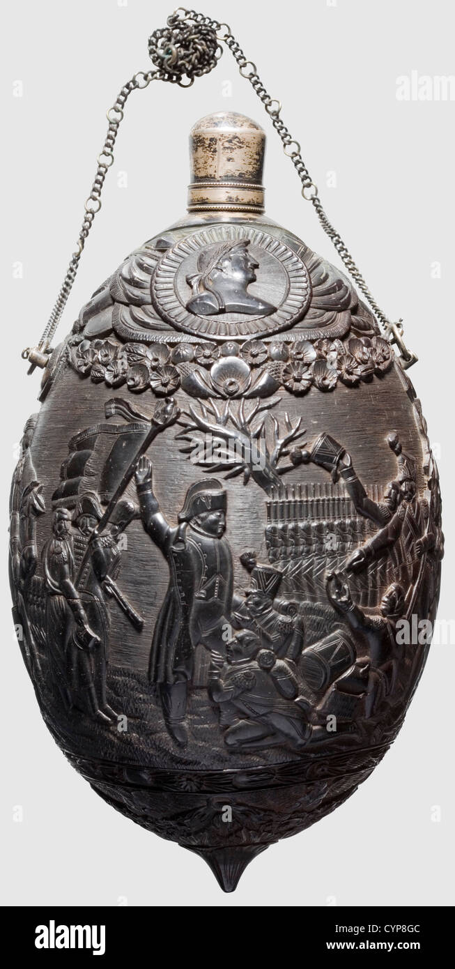 A colonial coconut bottle,circa 1800. The corpus continuously and lavishly carved in relief with depiction of Napoleon courted by his soldiers,on the reverse side scene of surrender with the handover of colours and sabre to Napoleon. At the bottom four eagles between floral frieze,the tip with medallion on one side surrounded by a bundle of trophies. Silver threaded spout and attached silver chain. Height 18 cm,historic,historical,people,19th century,France,Imperial,French Empire,object,objects,stills,clipping,cut out,cut-out,cut-outs,vessel,,Additional-Rights-Clearences-Not Available Stock Photo