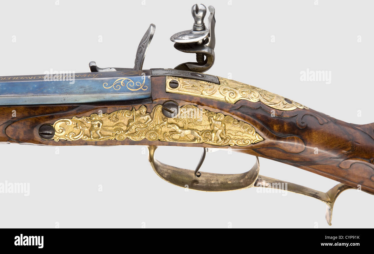 A very fine flintlock set consisting of a rifle and a pair of pistols,Carlsbad(?),circa 1760.The rifle with blued,octagonal barrel and seven-groove rifled bore in 15 mm calibre.Dovetailed,gilt sights.Gold-inlaid inscription 'Johann Haetischweiler in Carlsbad' on the breech,in front of that the Electoral Saxon coat of arms in a sun burst inlaid in gold and silver.Finely engraved flintlock with decorative hunting theme(cockjaw a replacement).Gold-lined vent hole.Sparsely carved full stock made from beautifully grained walnut.Furniture in lavish relie,Additional-Rights-Clearences-Not Available Stock Photo