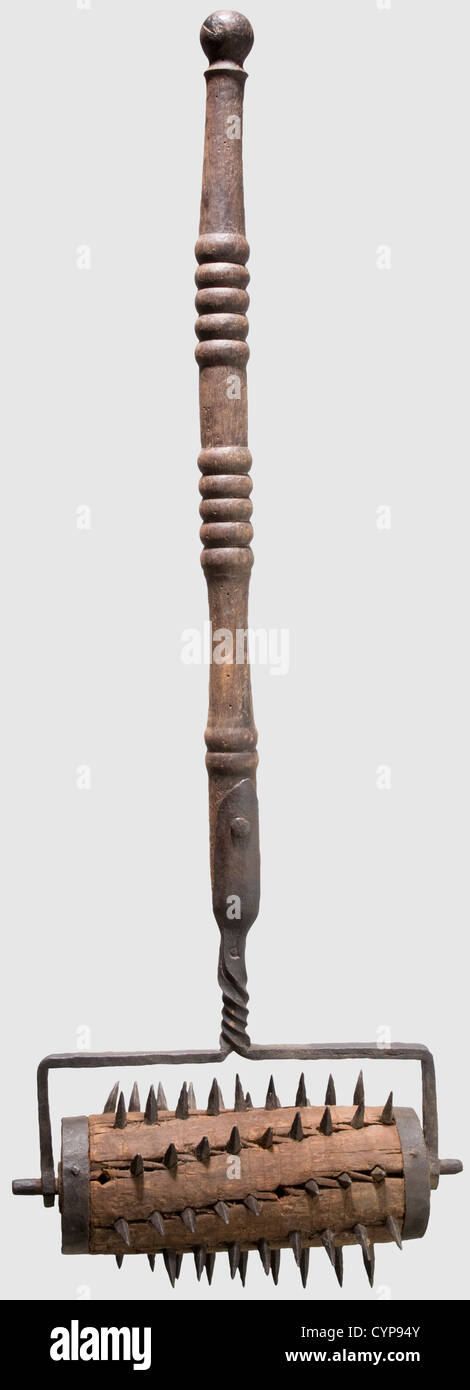 A German spike roller,16th/17th century. Wooden roller reinforced with iron straps,studded with several rows of quadrangular spikes(some of them missing). Turned baluster shaft(of later date?)with twisted iron mount stamped 'P' on the obverse. The wood of the roller cracked,the shaft with slight worming. Height 121 cm. Spiked torture devices were probably used to increase the pain of delinquents tied to the rack,historic,historical,,17th century,16th century,instrument of torture,torture device,instruments of torture,torture devices,object,objec,Additional-Rights-Clearences-Not Available Stock Photo