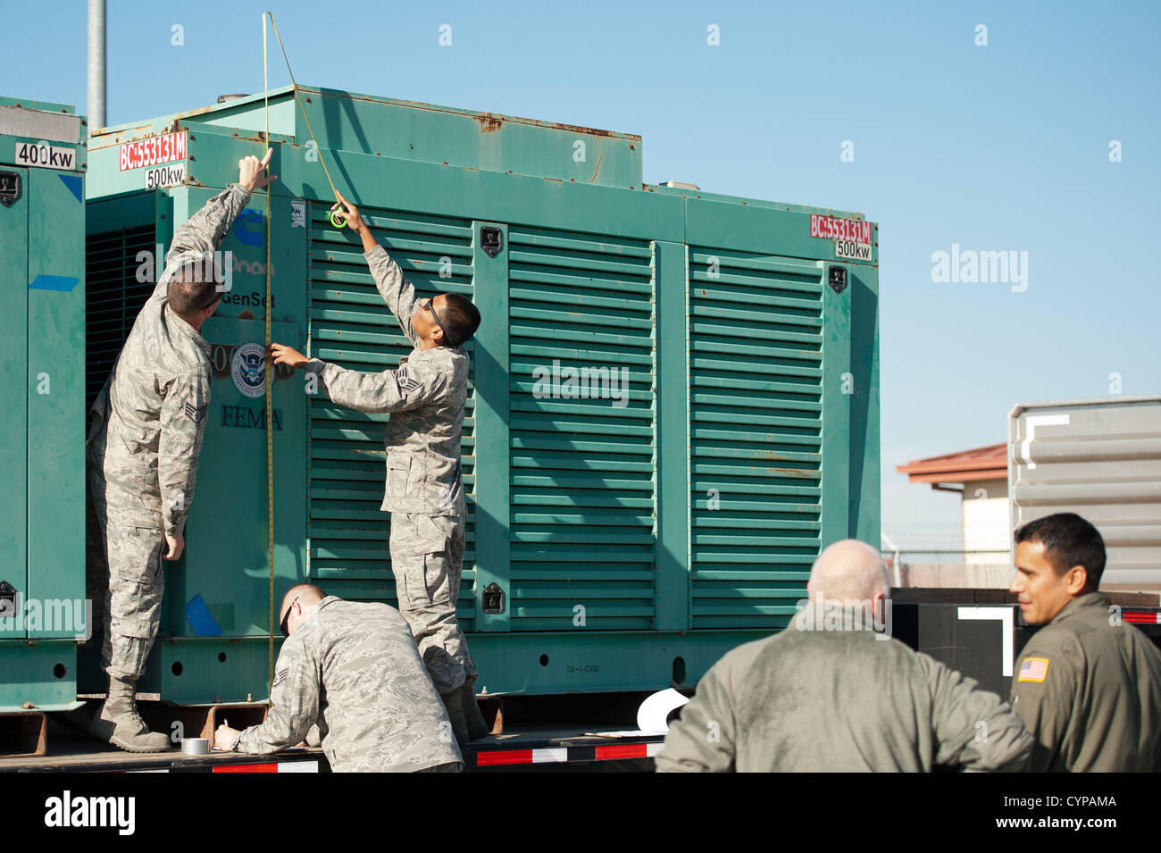 Massive 4,000 and 5,000 kilowatt generators and the 600 gallon diesel fuel tanks used to fuel them arrive At Travis Air Force Base from the Federal Emergency Management Agency at Moffet Field, California. The generators are secured to pallets and loaded o Stock Photo