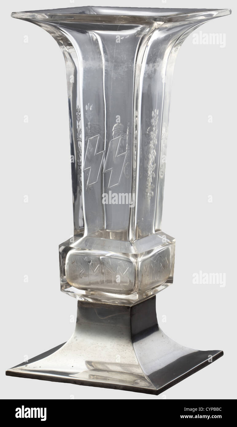 Theodor Eicke - a presentation vase,on the award of the Oak Leaves on 20 April 1942 Cut lead crystal glass displaying a Wehrmacht eagle on the obverse,the reverse shows SS runes,laterally oak leaves and swastika décor as well as a continuous runic inscription 'Meine Ehre heisst Treue'(My Honour is Loyalty).The silver base bears the engraved coat of arms of Theodor Eicke and the award date '20.April 1942',silver mark of fineness and maker's monogram.Height 34 cm.Small chips and scratches,but in good overall condition.Theodor Eicke,founder and command,Additional-Rights-Clearences-Not Available Stock Photo
