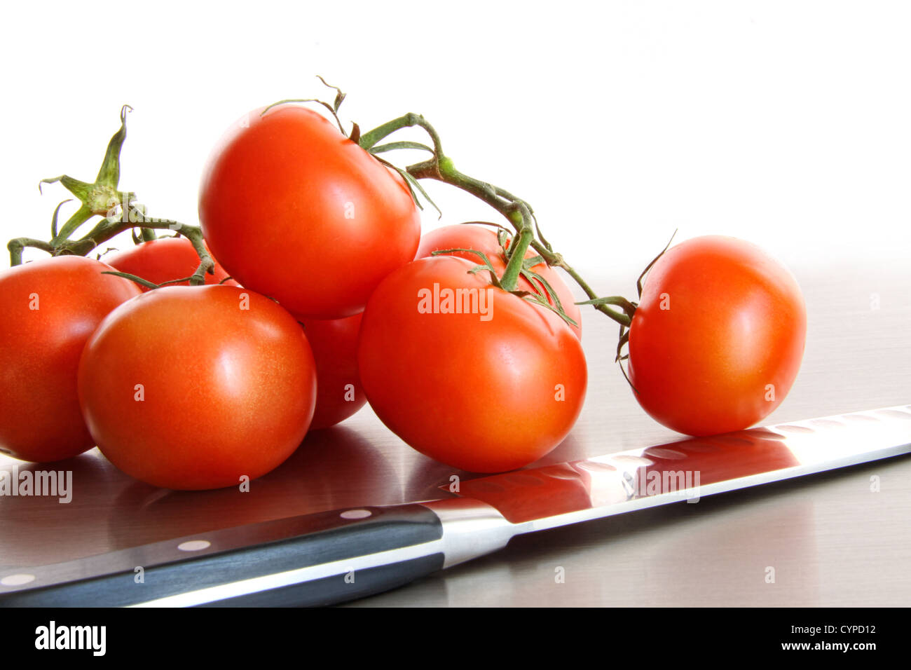 Fresh ripe tomatoes on stainless steel counter with white background