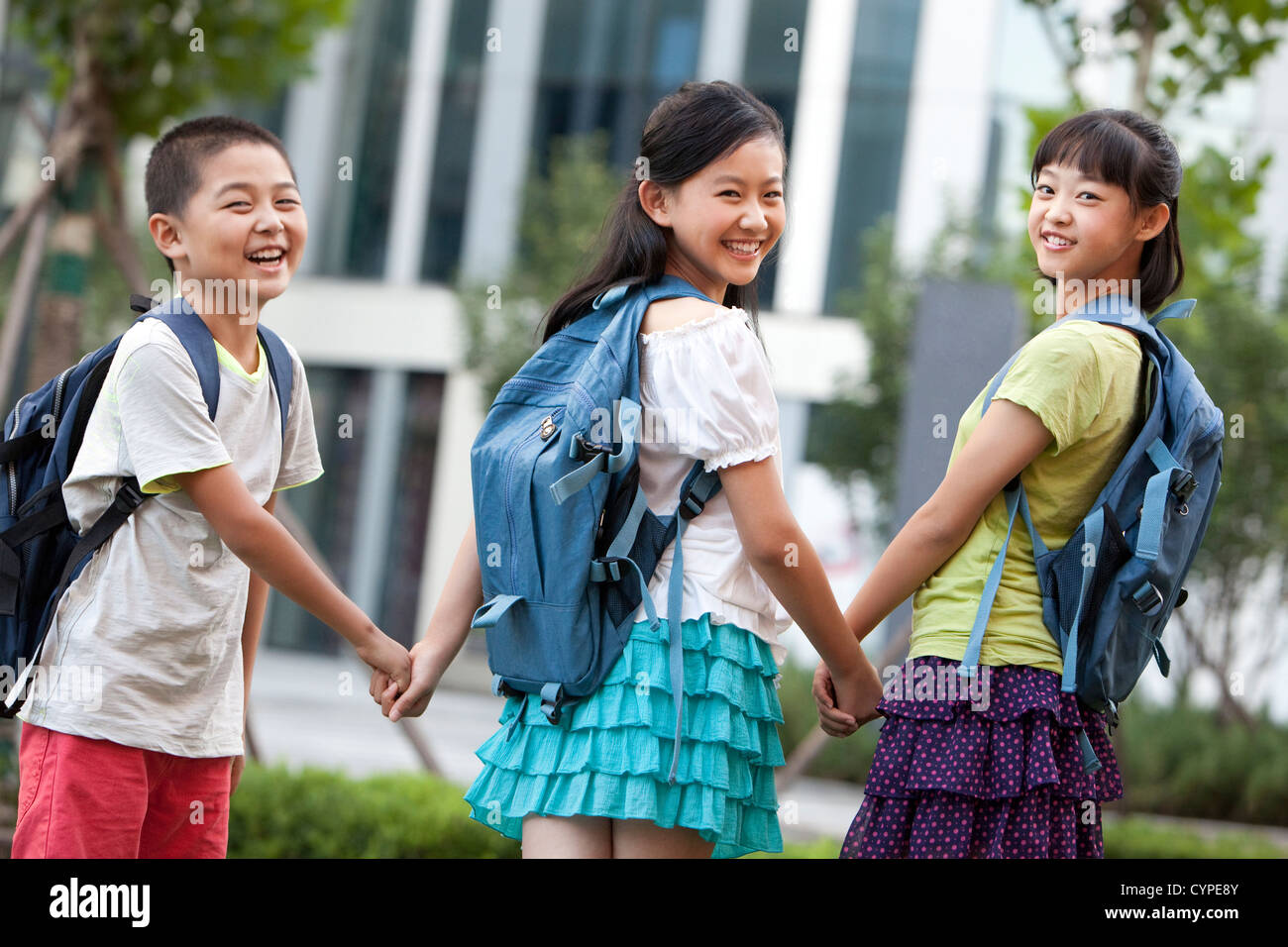 Happy schoolchildren holding hands Stock Photo - Alamy