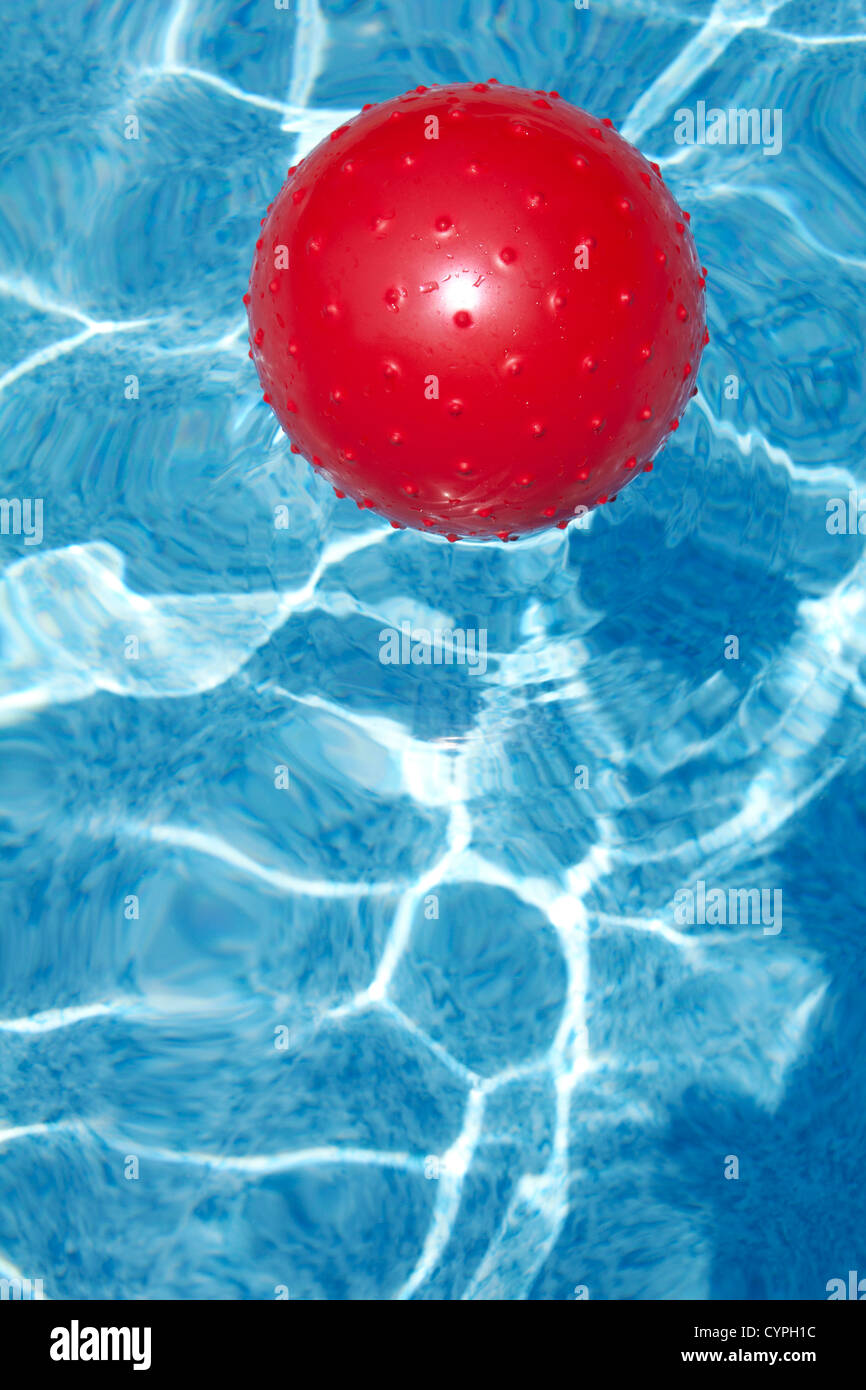 Red ball floating in pool Stock Photo