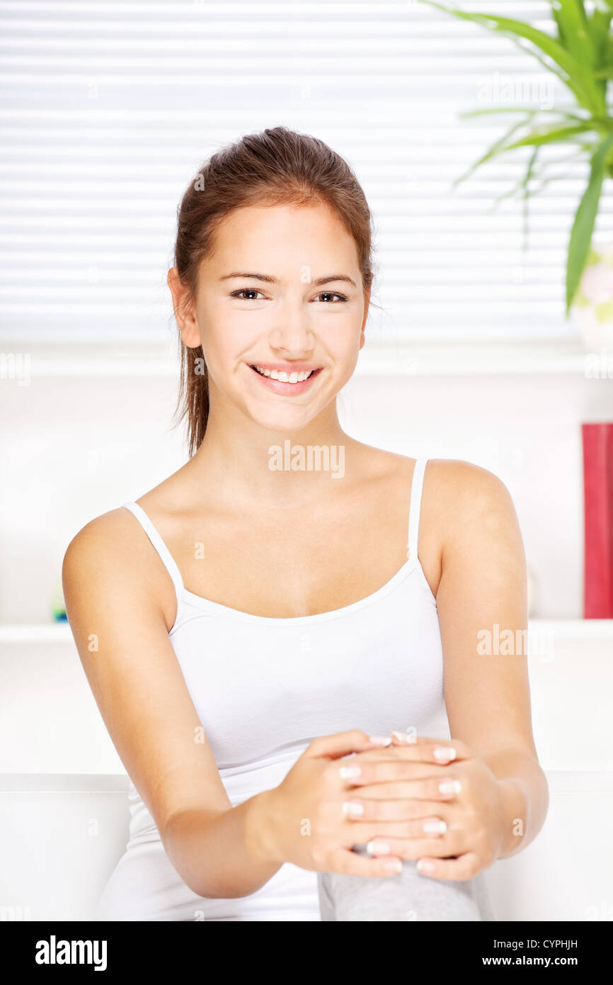 pretty young woman at home sitting on the sofa Stock Photo