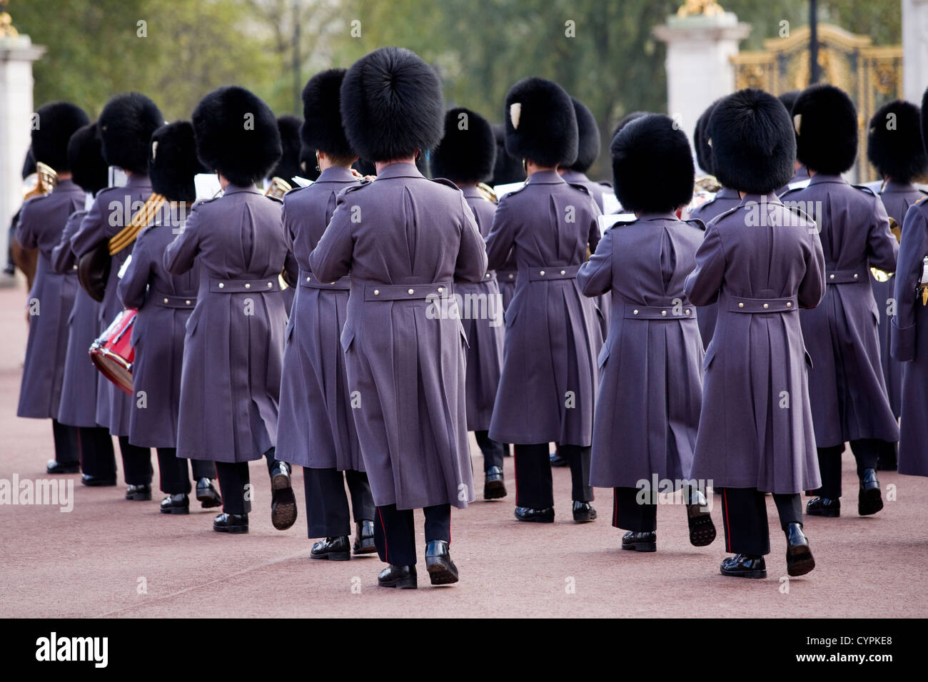 Bandsmen in great coat & bearskin bear skin hat s shown from the back during Changing Of The Guard. Buckingham Palace London UK Stock Photo