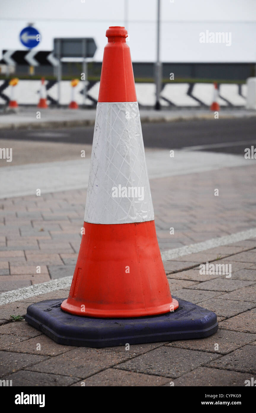 UK Traffic Cone in the road with roundabout in the background Stock